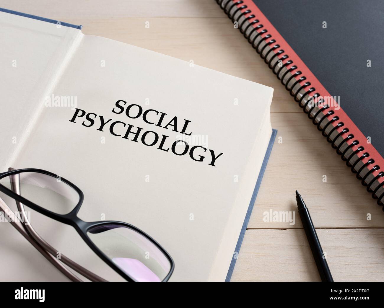 Sozialpsychologie mit dem Titel Lehrbuch auf dem Schreibtisch. Stockfoto