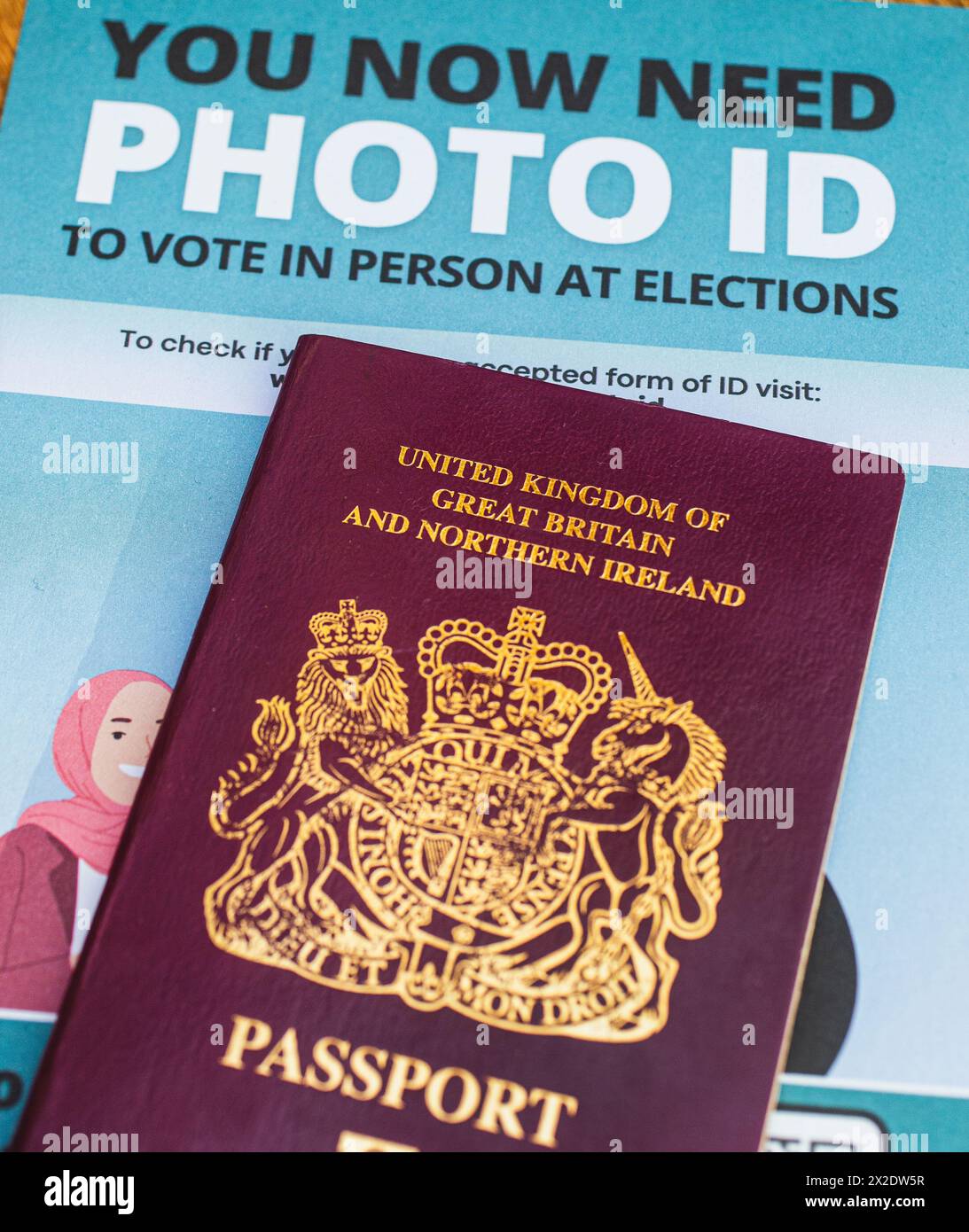 Britischer Reisepass mit einem Faltblatt, aus dem hervorgeht, dass die Wähler in England bei einigen Wahlen einen Lichtbildausweis vorlegen müssen, um an Wahllokalen wählen zu können. UK Stockfoto