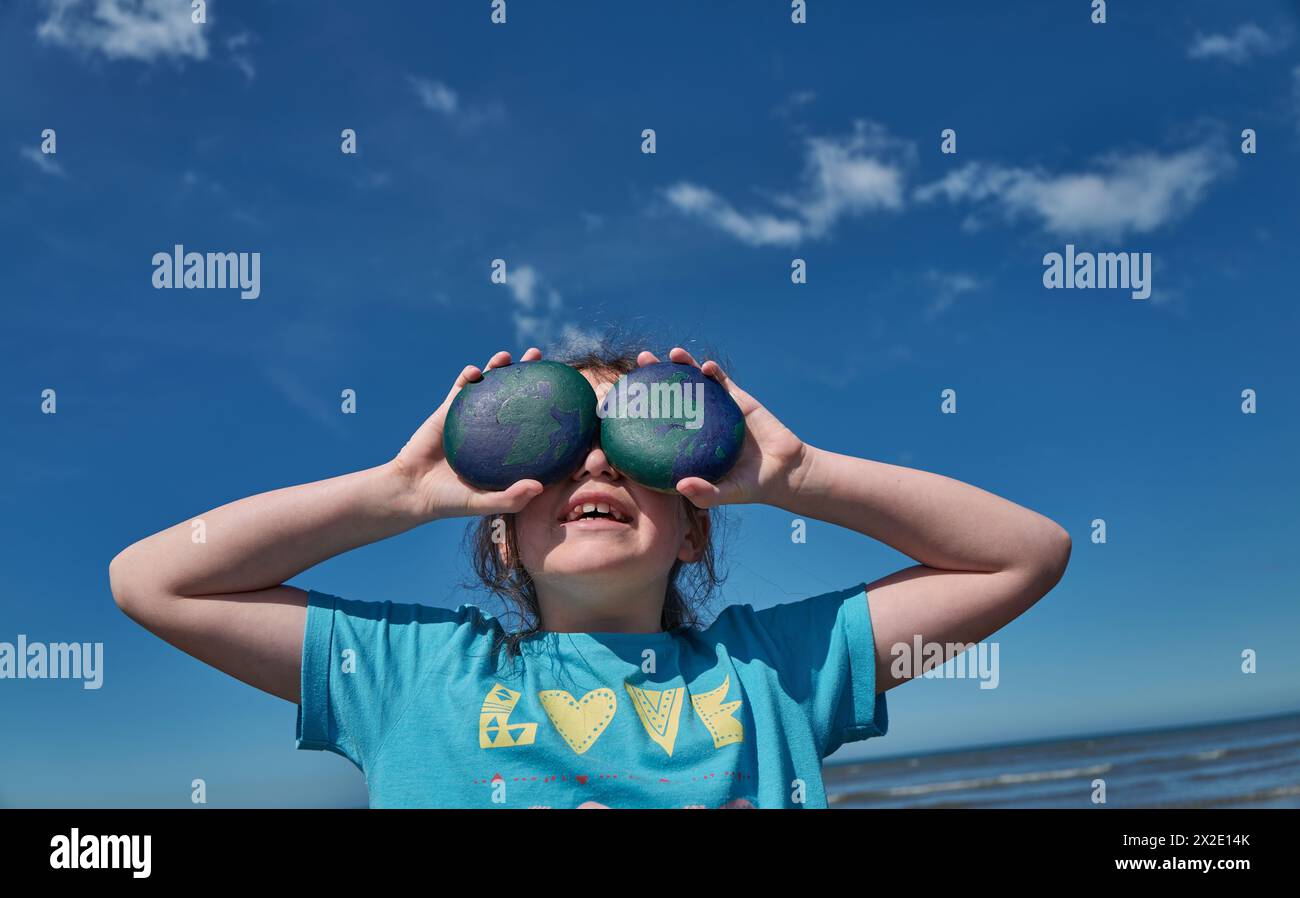 Kinder spielen am Strand von Westward Ho!, Devon mit ihren erdgemalten Kieseln zum Welttag der Erde am 22. April 202 Stockfoto