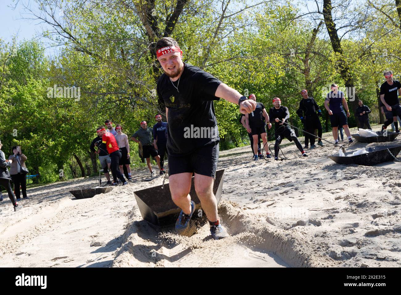 KIEW, UKRAINE - 20. APRIL 2024 - Ein Mann zieht während des Benefizrennen Spartan Kiew 2024 auf der Insel Truchaniv, Kiew, Hauptstadt der Ukraine, Ein Seil. Die Veranstaltung wird durchgeführt, um Geld für Drohnen für Militärangehörige und einen schwer verwundeten Soldaten des Verteidigungsnachrichtendienstes der Ukraine zu sammeln. Stockfoto