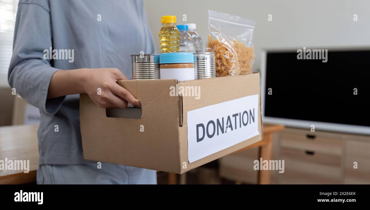 Eine Freiwillige hält eine Lebensmittelspendebox zu Hause Stockfoto