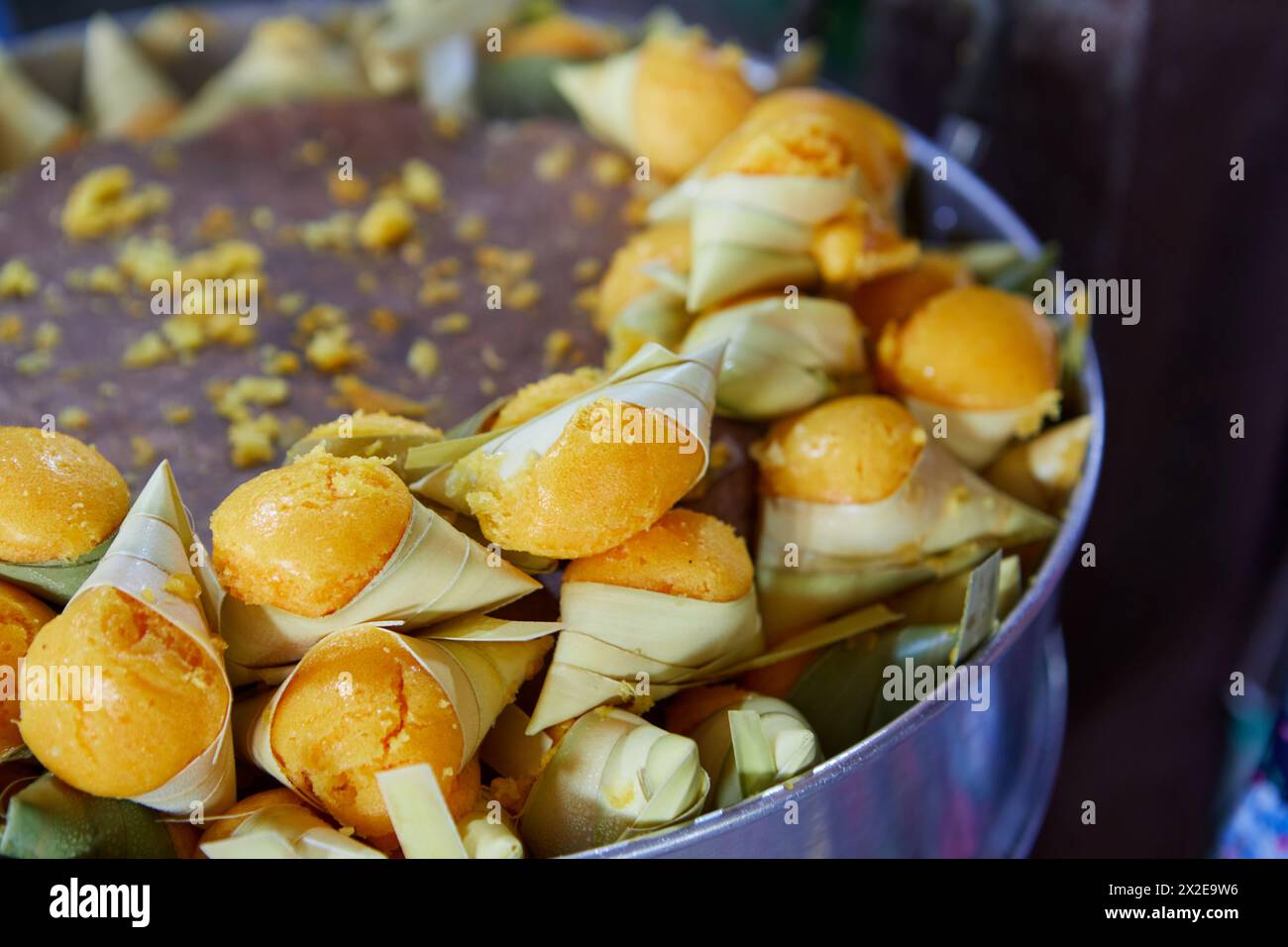 Gedämpfter Khanom Tarn oder kleiner Palmkuchen, mit Palmblatt in Topf gewickelt Stockfoto