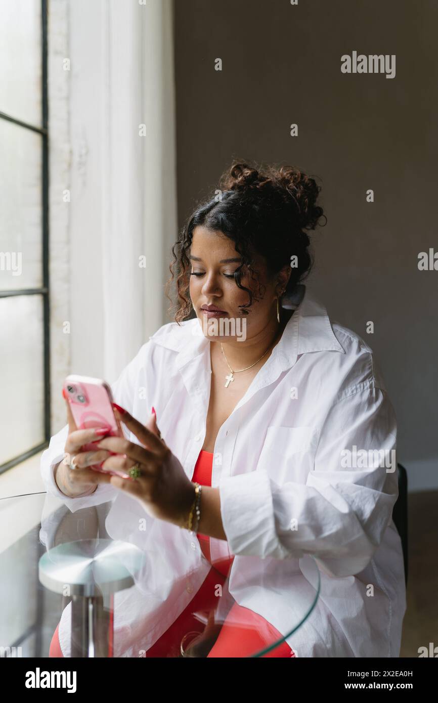 Schwarze Frau, die von zu Hause aus am Telefon arbeitet Stockfoto