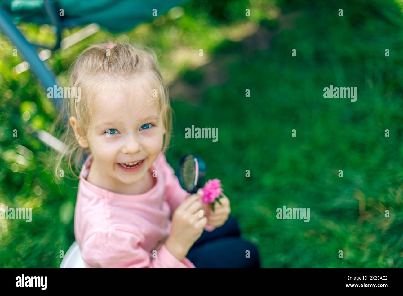 Kleines Mädchen mit Blumen auf dem Land im Hinterhof Stockfoto