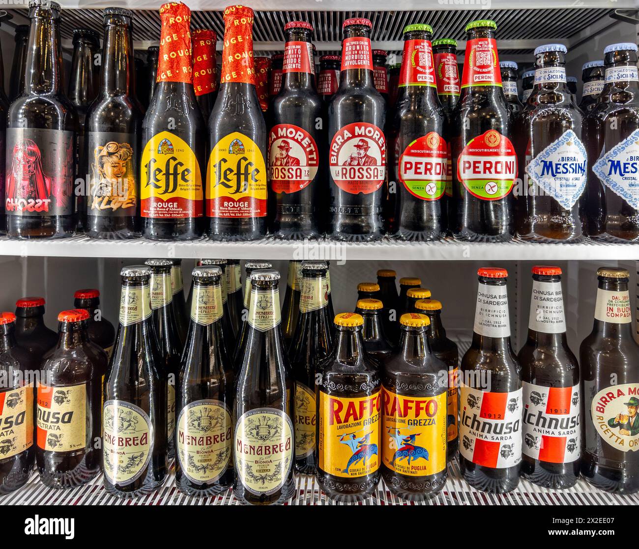 Italien - 04. april 2024: Bier in Glasflaschen verschiedener Typen und Marken in Kühltheken. Italienische, sizilianische und sardische Biere und Leffe-Biene Stockfoto