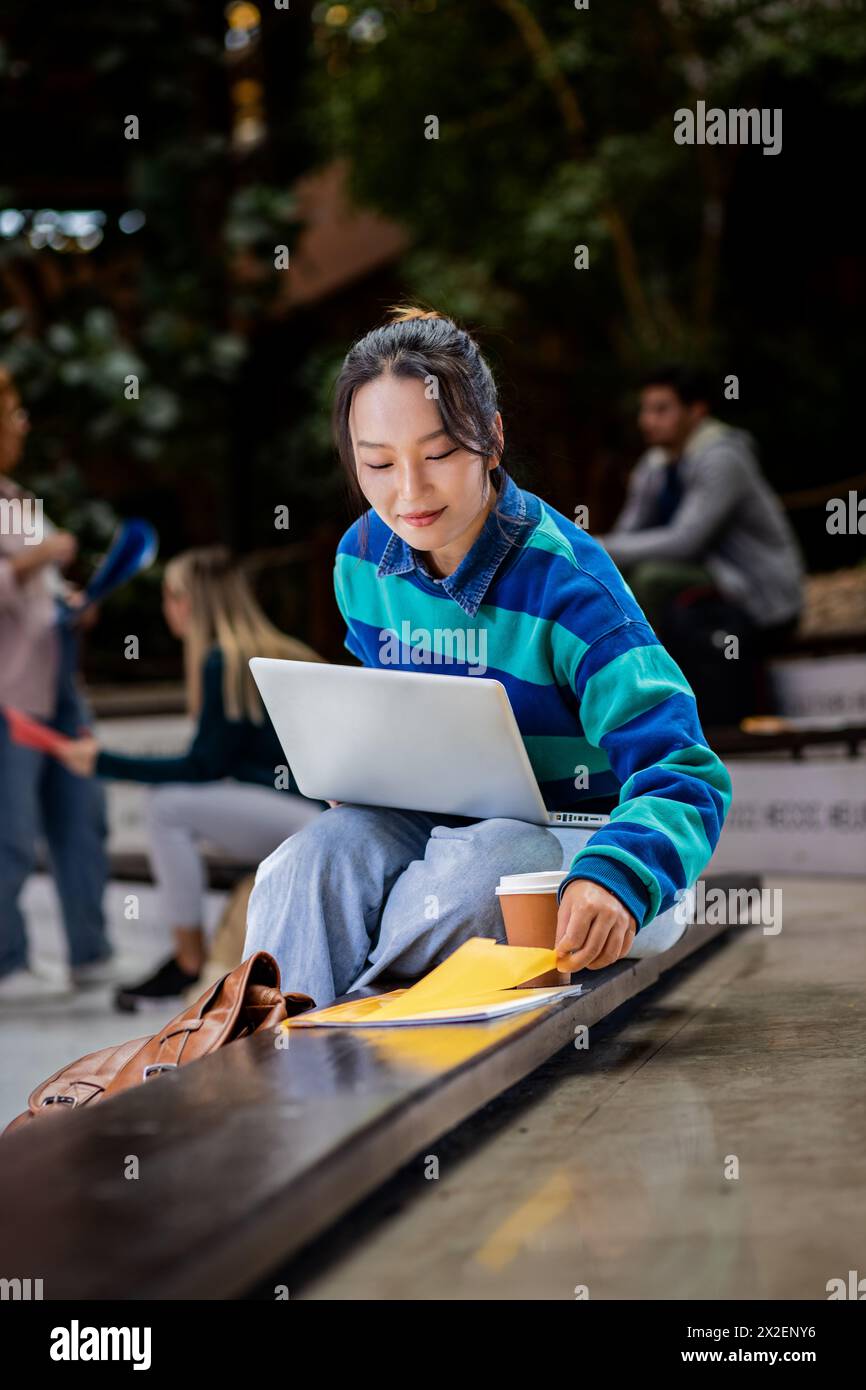 Porträt einer Studentin auf dem Campus mit Laptop. Stockfoto