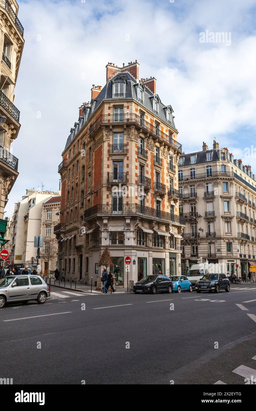 Historische Pariser Ecke mit Haussmann-Gebäuden und geschäftigem Straßenleben. Stockfoto