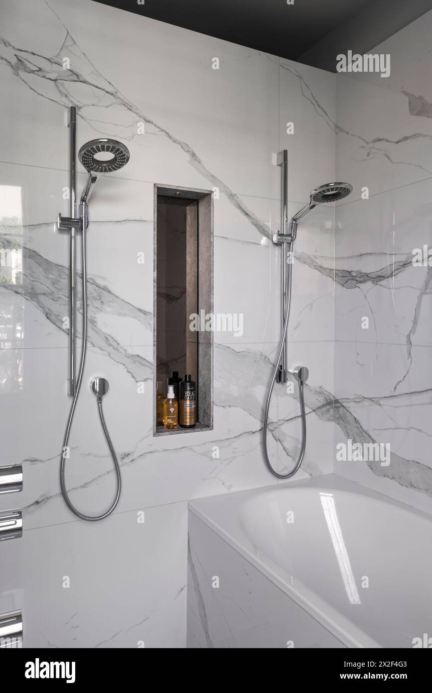 Einrichtung mit zwei Duschen in einfachem, modernem Marmorbad im georgianischen Stadthaus. Paultons Square, Chelsea, London, Großbritannien. Stockfoto
