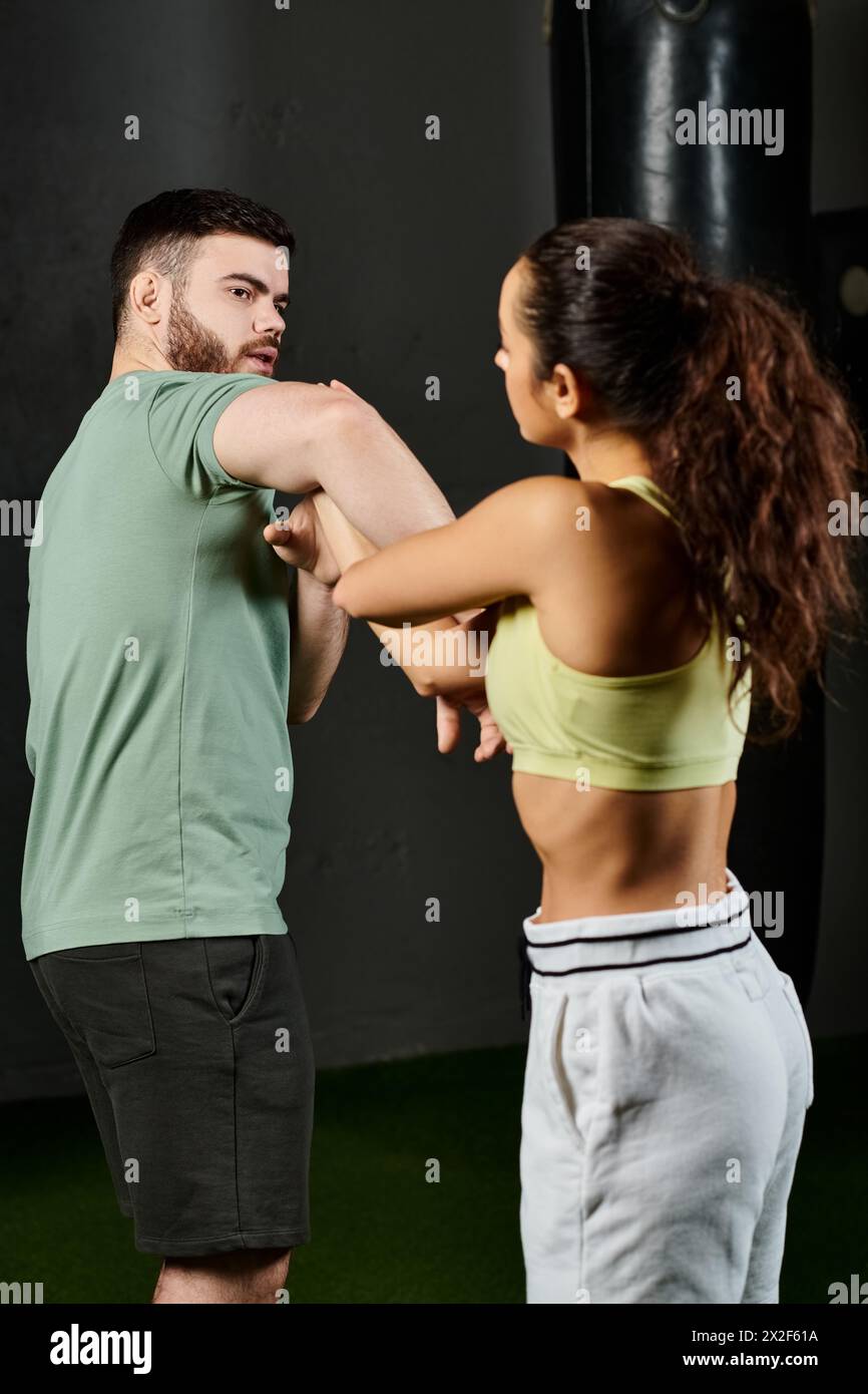 Ein männlicher Trainer bringt einer Frau im Fitnessstudio Techniken zur Selbstverteidigung bei. Stockfoto