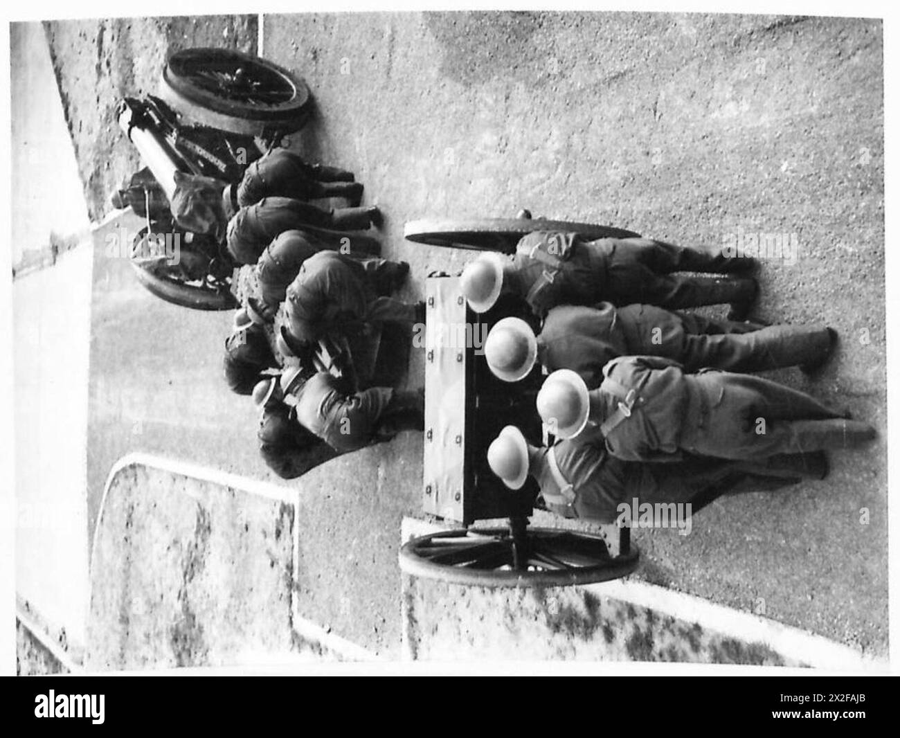 Ein Foto aus dem Zweiten Weltkrieg zeigt Rekruten der britischen Armee, die während der Trainingsübungen eine 6-Zoll-Haubitze vorbereiten. Das Bild zeigt den Prozess der Einengung des Artilleriegeschosses und demonstriert die Ausbildung zukünftiger Schützen. Stockfoto