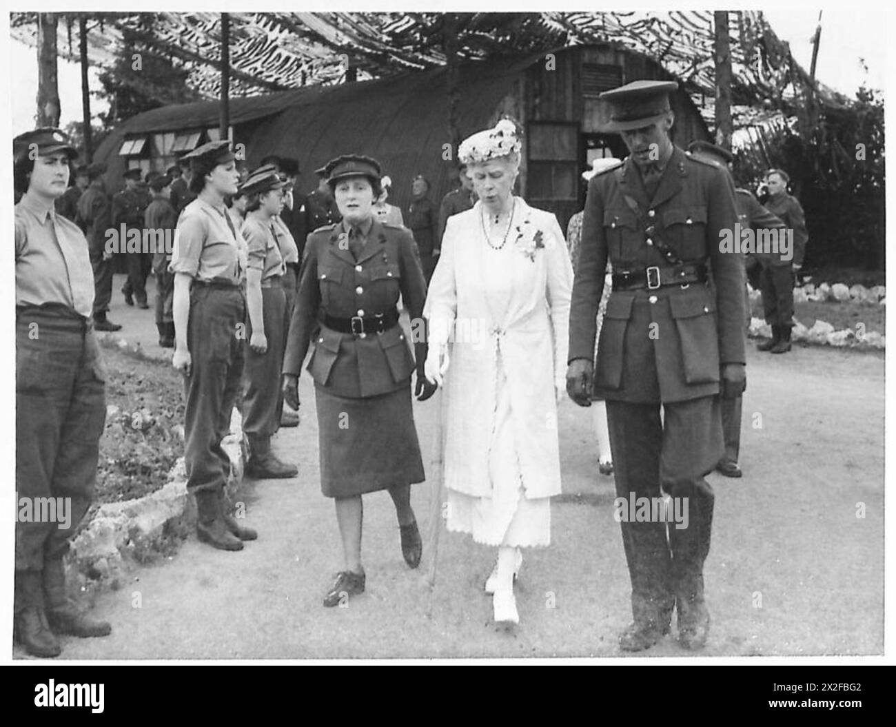 Königin Mary besucht eine gemischte Flugabwehrbatterie, in der ATS-Mitarbeiter eine Ehrengarde für sie bilden und militärische zeremonielle Aufgaben demonstrieren. Stockfoto