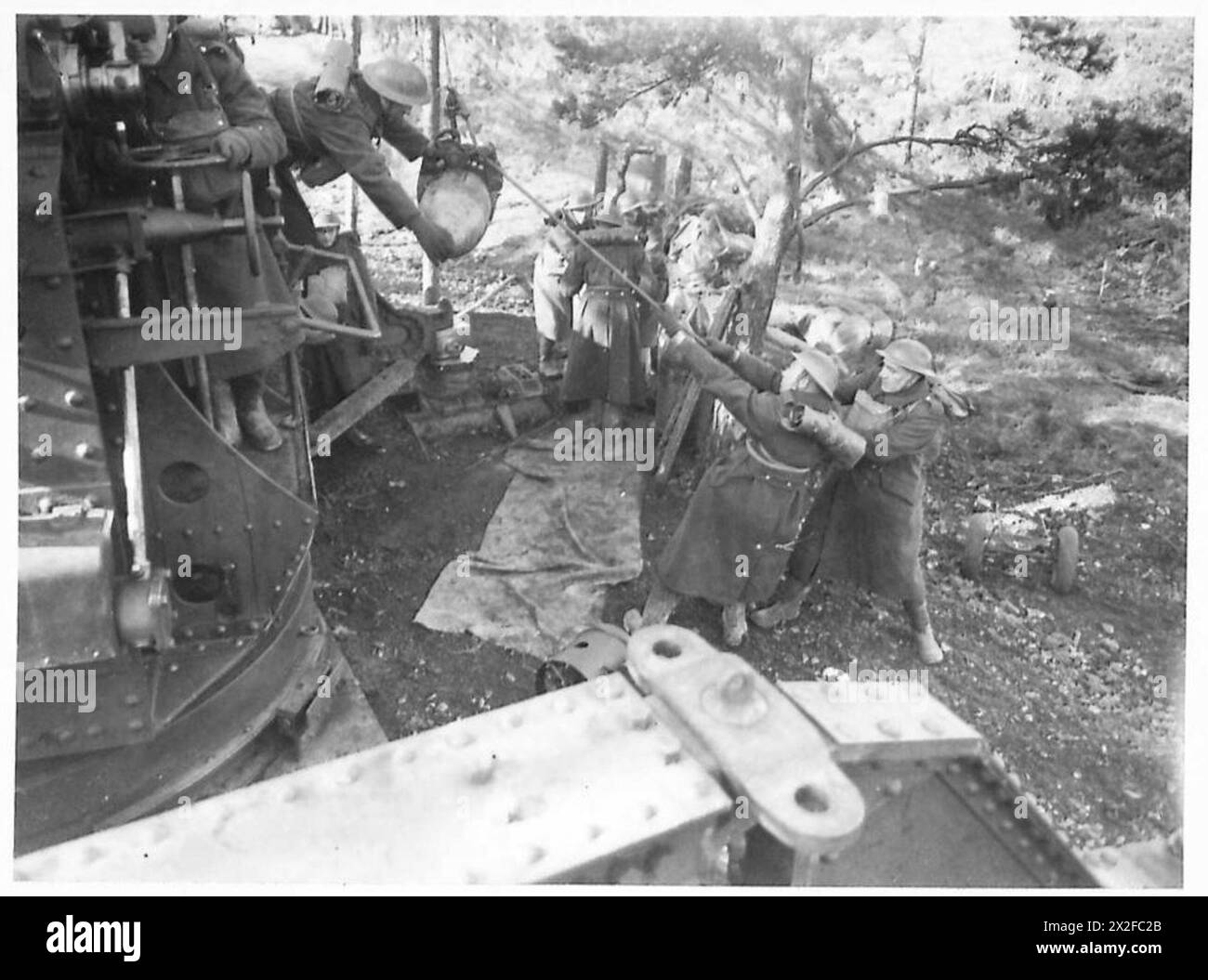 Eine Granate wird auf eine Laderiege gehoben, die die Vorbereitung und Handhabung der Artillerie in der britischen Armee darstellt. Stockfoto