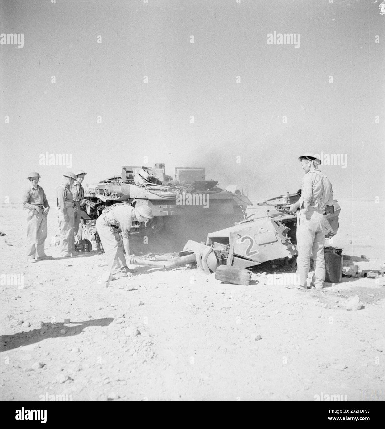 Britische Truppen inspizieren einen deutschen PzKpfw III-Panzer, der am 2. Juni 1942 während nordafrikanischer Operationen durch eine 2-Pfünder-Panzerabwehrkanone in der Westwüste zerstört wurde. Stockfoto