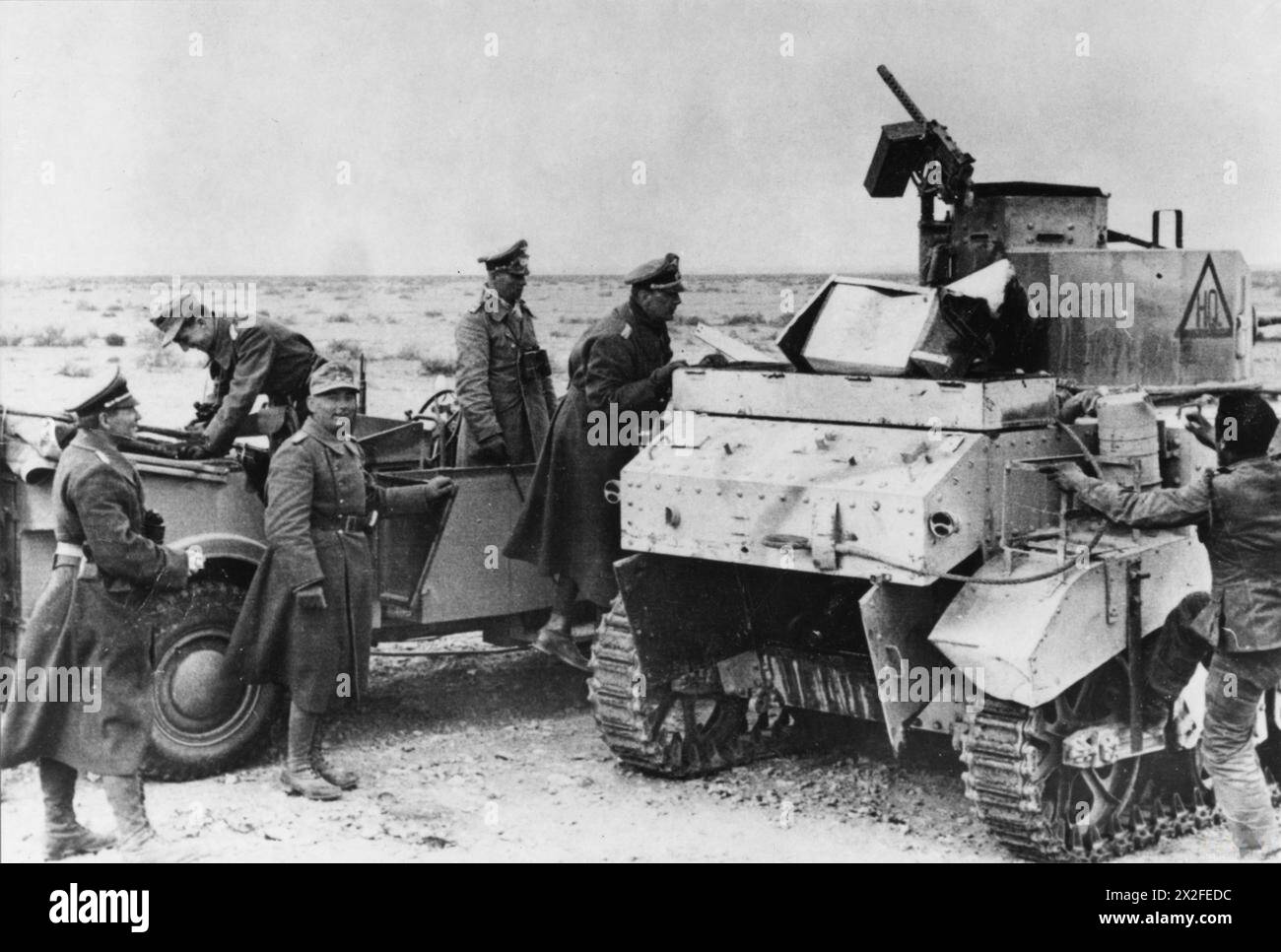 Feldmarschall Erwin Rommel und Stabsoffiziere inspizieren im April 1942 während der Operationen der deutschen Armee in Nordafrika einen kaputten britischen M3 Stuart-Panzer in der Westwüste. Stockfoto