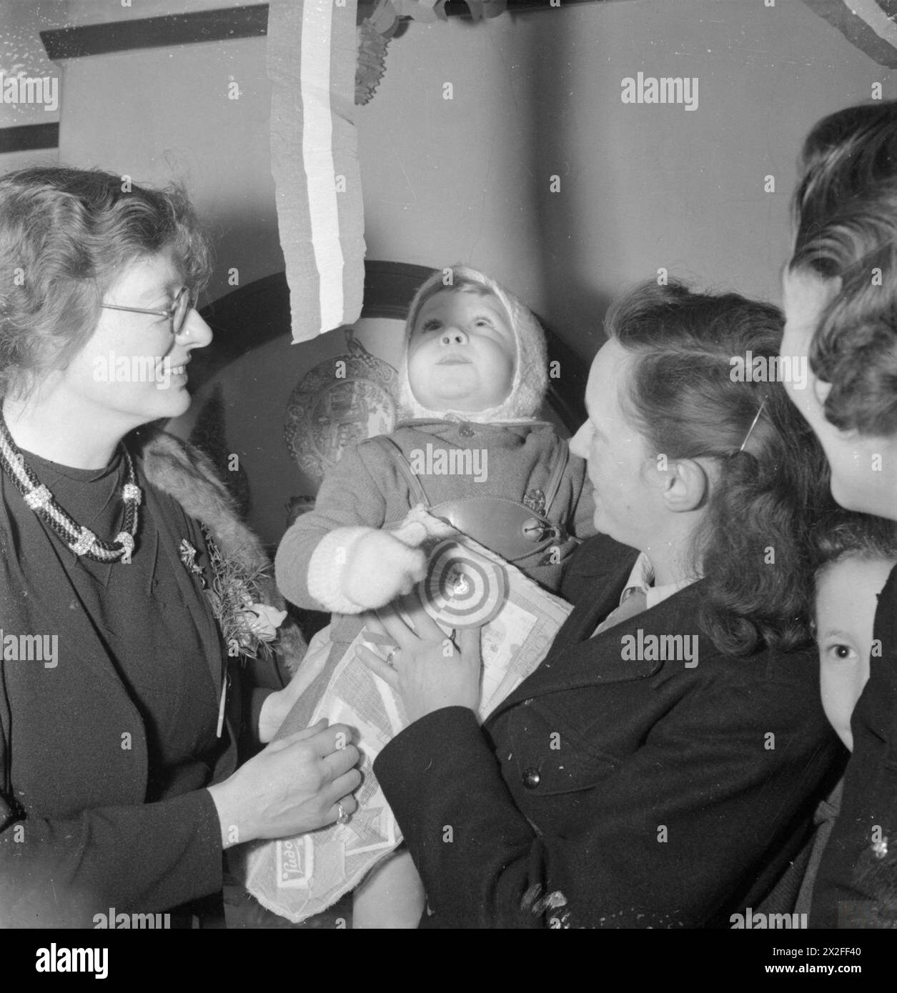 Im Dezember 1944 hilft Wärterin Constance Holland Frau R Myner bei der Auswahl eines Spielzeugs für ihren zweijährigen Sohn William Charles. Stockfoto