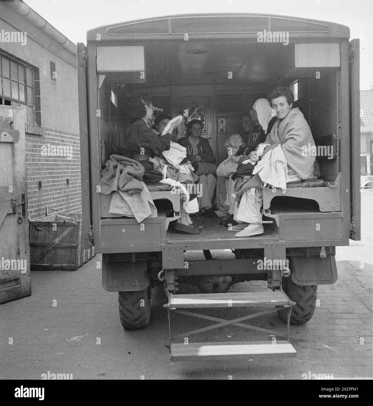 Ehemalige Häftlinge von Bergen-Belsen sitzen im Mai 1945 in einem Lastwagen und werden nach der Befreiung in die Hohne-Militärkaserne gebracht. Stockfoto