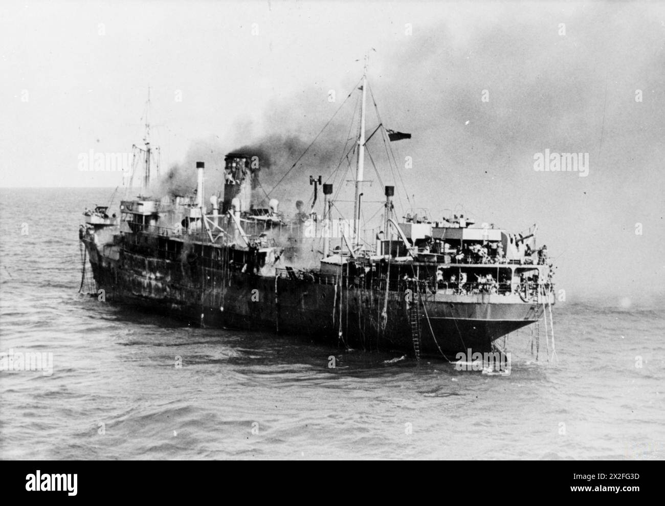 Der Escortträger HMS Trouncer rettete 420 Überlebende aus der brennenden SS Empire Patrol vom 29. Bis 30. September 1945. Das Schiff geriet in Brand, als es nach dem Zweiten Weltkrieg griechische Flüchtlinge aus Abessinien nach Ostafrika zurückbrachte Stockfoto Der Escortträger HMS Trouncer rettete 420 Überlebende aus der brennenden SS Empire Patrol vom 29. Bis 30. September 1945. Das Schiff geriet in Brand, als es nach dem Zweiten Weltkrieg griechische Flüchtlinge aus Abessinien nach Ostafrika zurückbrachte Stockfoto