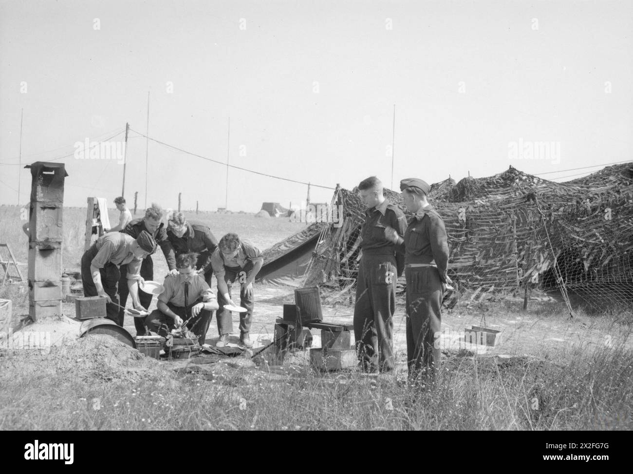 Das Abendessen wird dem Personal der No. 83 Group Signals Unit, 2nd Tactical Air Force, in einem Feld in der Nähe von Bazenville, Normandie, 1943-1945, serviert. Wartungseinheiten 63 und 201 unterstützen die Arbeiten. Stockfoto