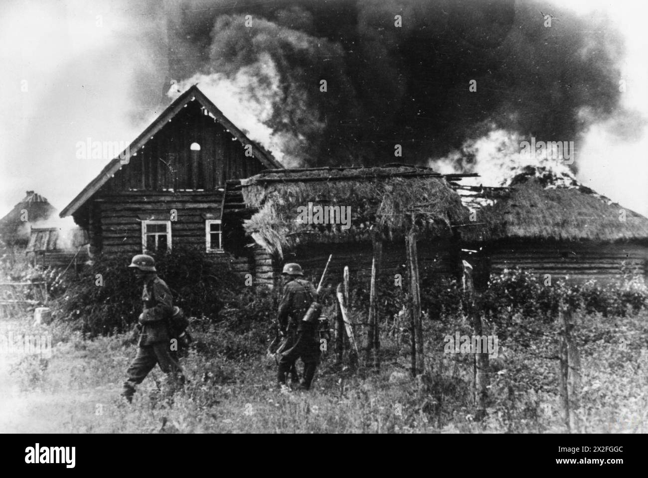 Deutsche Truppen besetzen während der Operation Barbarossa im Sommer 1941 ein brennendes russisches Dorf. Stockfoto