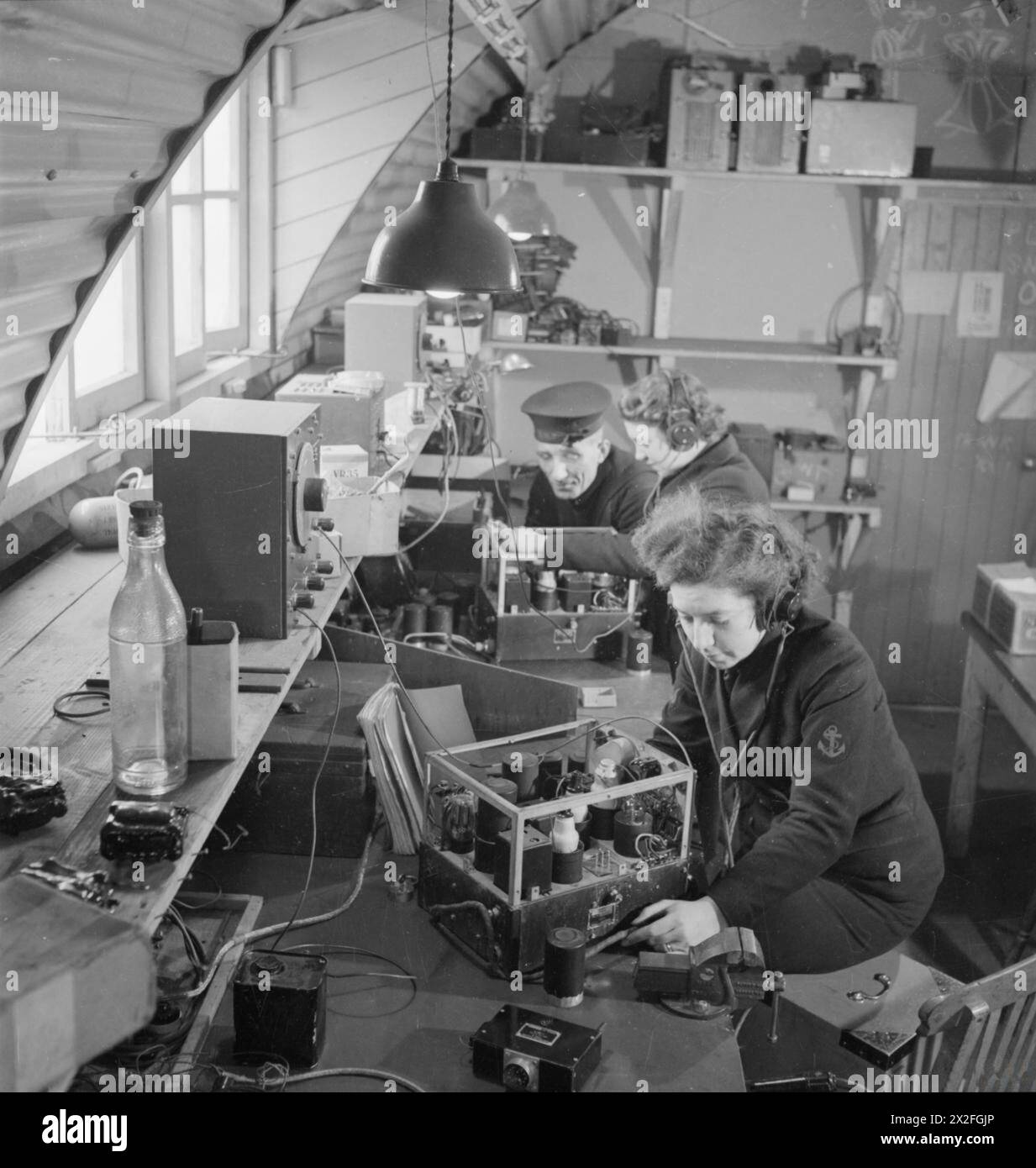 ROYAL MARINESERVICE FÜR FRAUEN: MIT DER FLOTTENLUFTWAFFE, SCHOTTLAND, 1943 - zwei Wren Radio Mechanics arbeiten mit einer Marineschifffahrtsklasse, um Funkempfänger in der Radiowerkstatt Women's Royal Naval Service zu testen Stockfoto