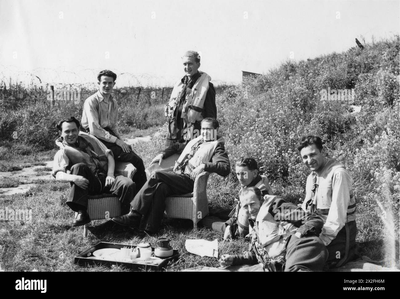 DIE POLNISCHE LUFTWAFFE IN GROSSBRITANNIEN, 1940-1947 - Piloten des B-Fluges, Nr. 303 polnische Jagdgeschwader, die ein Picknick genießen, während sie auf einen Rastanruf bei der RAF Northolt warten, 29. August 1942.von links nach rechts - Fliegender Offizier Longin Majewski, Pilot Offizier Mirosław Szelestowski, Sergeant Alojzy Rutecki (stehend), fliegender Offizier Antoni Kolubiński, Sergeant Stanisław Górny, Sergeant Włodzimierz Chojnacki und Pilot Tadeusz Powierza polnische Luftwaffe, polnische Luftwaffe, 303 'Kościuszko' Jagdgeschwader, Majewski, Longin, Rutecki, Alojzy, Szelestowski, Mirosław, Kolubiński, Antoni Michał, Górny, Stanis Stockfoto