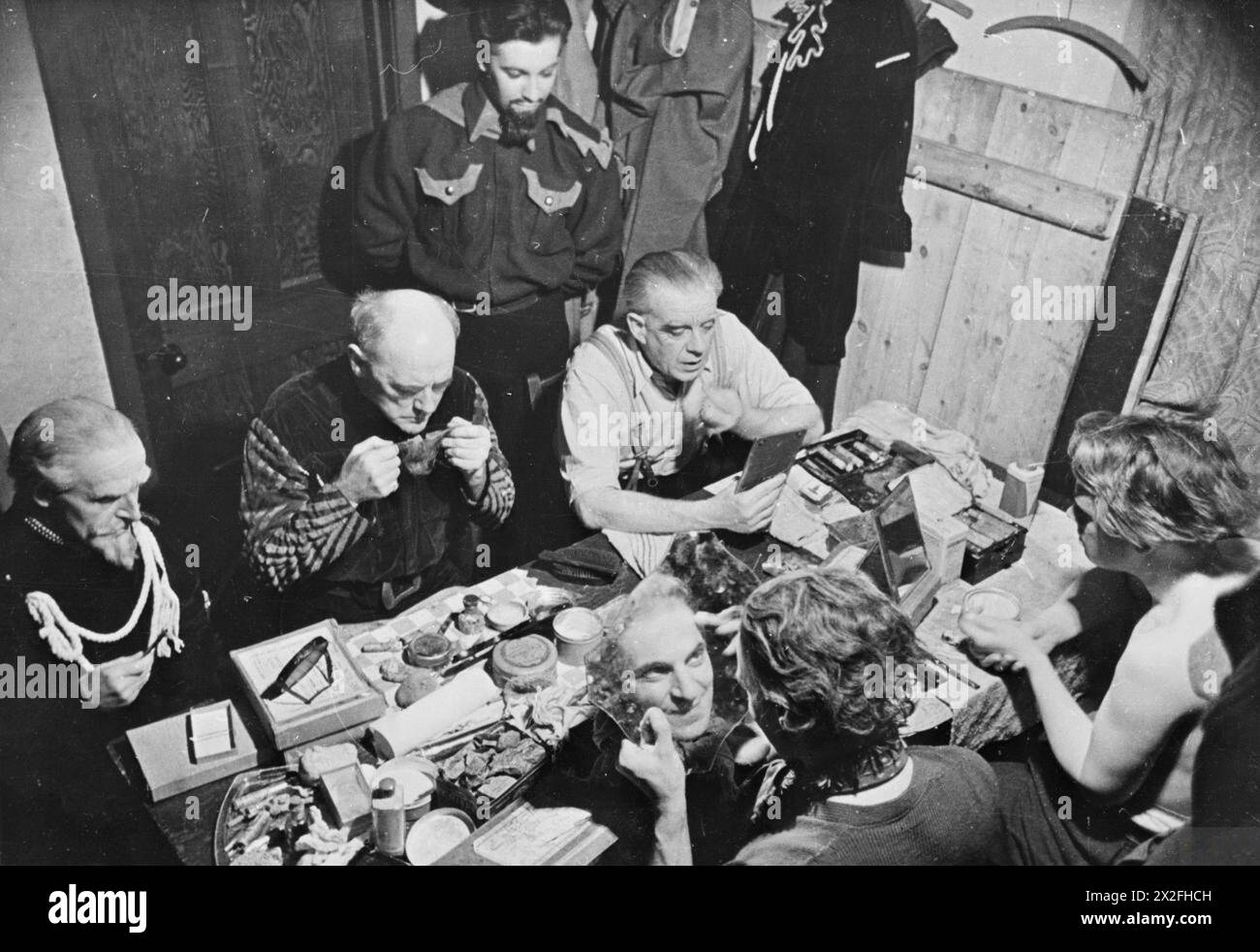 Mitglieder der Old Vic Traveling Theatre Company, darunter John Garside, Lewis Casson, Raymond Scott, Charles Staite, Alec Mango und John Larne schminken 1941 in einem Ankleidezimmer in der Settlement Hall, Trealaw, Wales, während sie sich auf eine Vorstellung von „Medea“ auf ihrer von der CEMA unterstützten Tour vorbereiten. Stockfoto