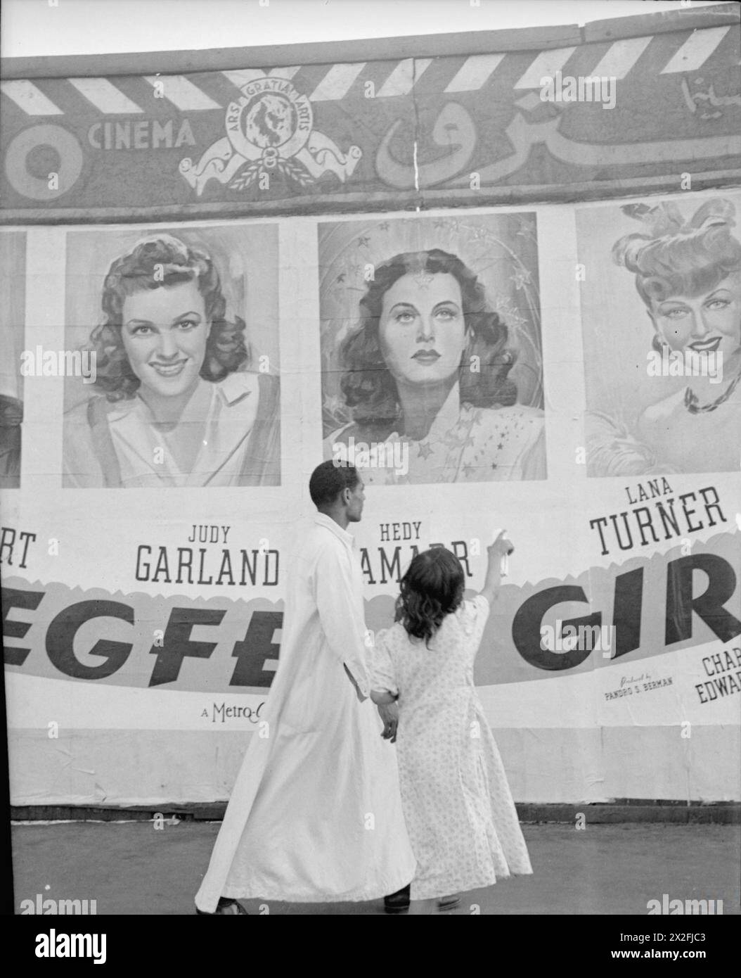 Ein Hollywood-Filmplakat in Kairo (Ägypten) von 1942 zieht die Aufmerksamkeit der einheimischen Ägypter auf sich, aufgenommen auf einem Foto von Cecil Beaton während seiner Nahost-Tour vom Februar bis Juli 1942. Stockfoto