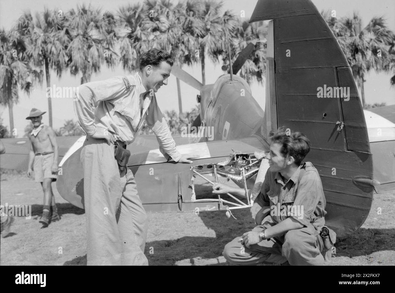 KÖNIGLICHE LUFTWAFFE IM FERNEN OSTEN, 1941-1945. - Polizeibeamter R E Partidge von Brisbane, Australien (links) und Sergeant Cyril Potter aus Northampton, zwei Piloten der No. 152 Squadron RAF in Sinthe, Burma, untersuchen die Schäden, die am Aufzug von Potters Supermarine Spitfire Mark VIII während eines Hundesampfes mit der japanischen Royal Air Force "Oscars" verursacht wurden. Royal Air Force Regiment, Sqdn, 152 Stockfoto