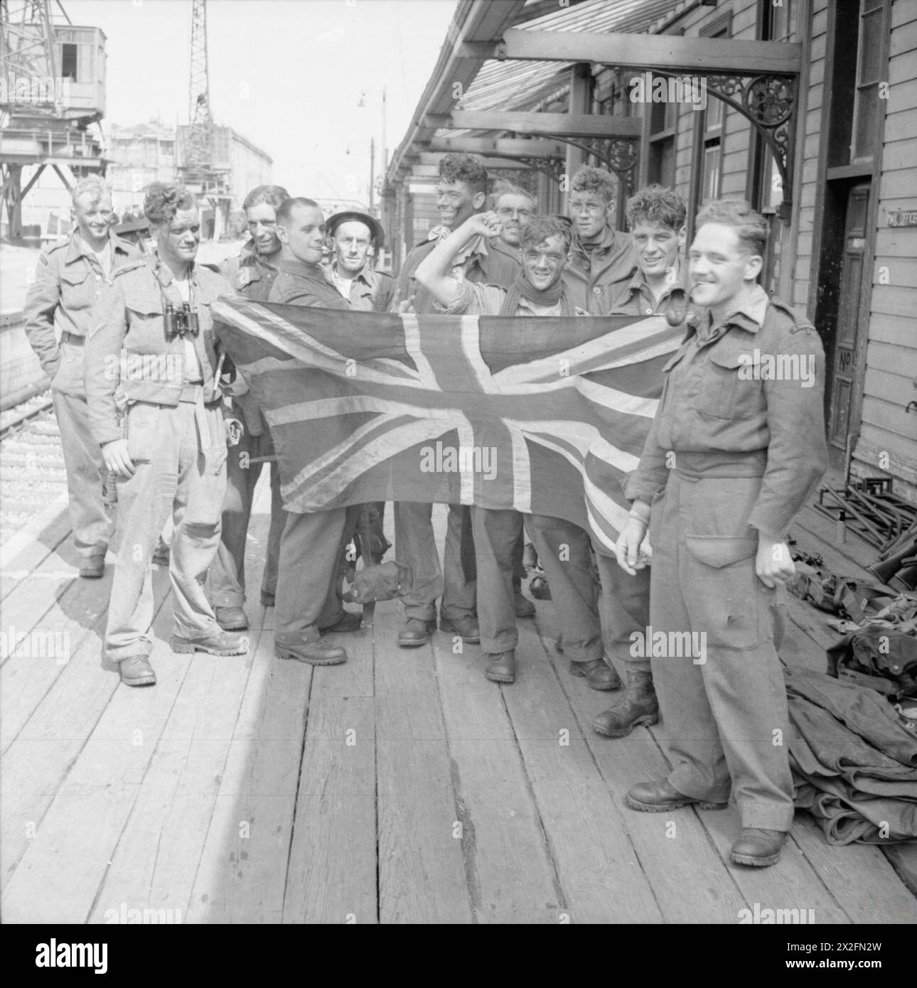 Das Foto zeigt Teilnehmer des Dieppe-RAID am 19. August 1942, einige posierten mit einer Flagge der Union Jack auf den Klippen von Dieppe während der Operation im Zweiten Weltkrieg. Stockfoto