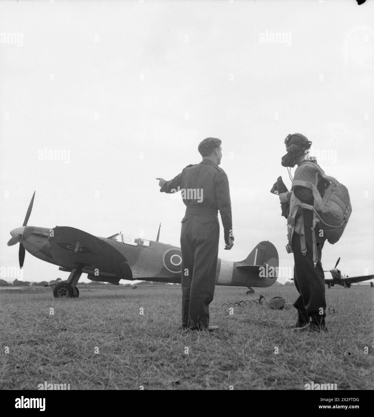 Bei der No. 61 Operational Training Unit in Rednal, Shropshire, wird ein neu qualifizierter Pilot von seinem Ausbilder in den Jahren 1939 bis 1945 in die Supermarine Spitfire Mark IIB, P8315 eingeführt. Stockfoto