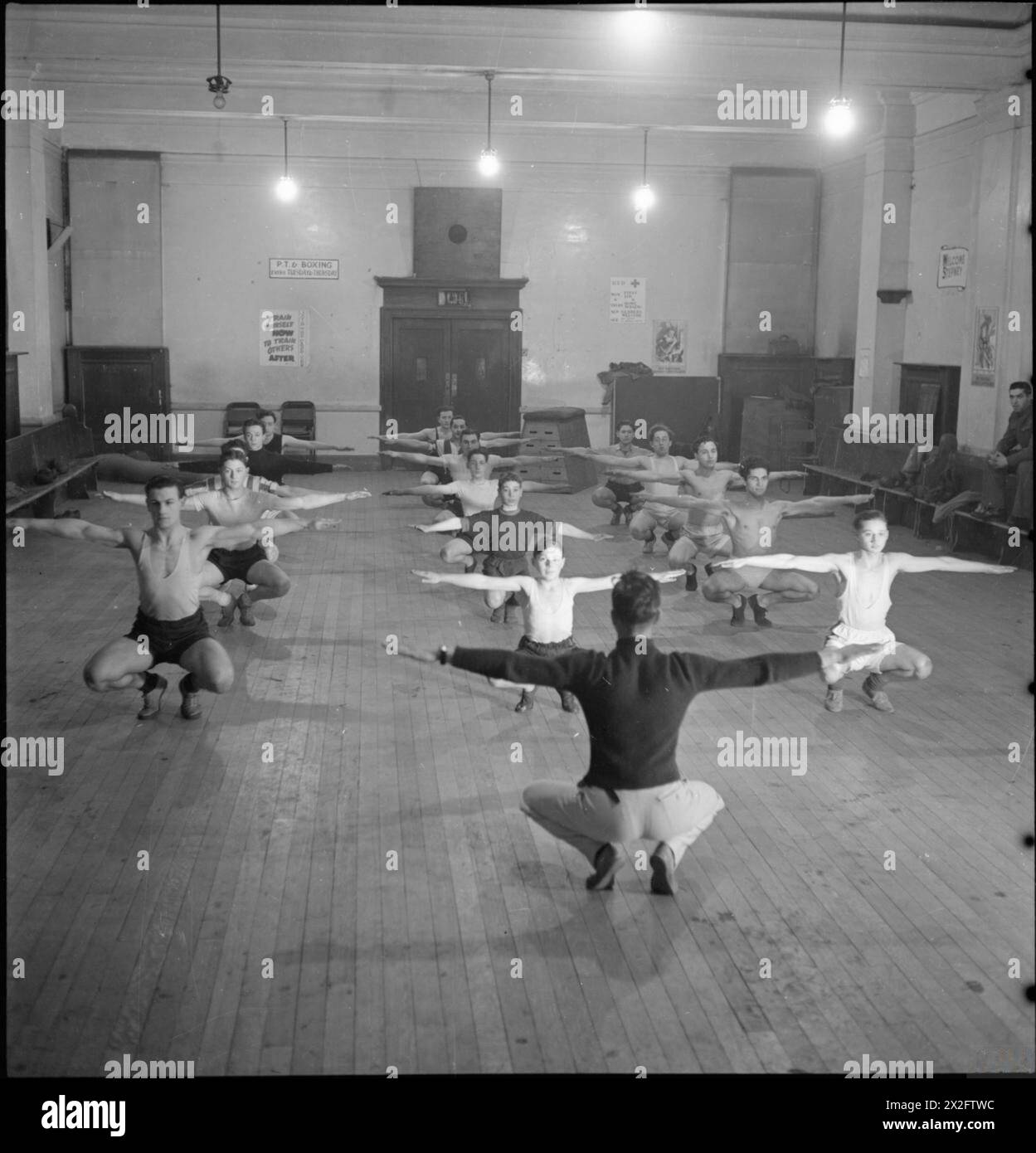 Die Jungen der Bernhard Baron Settlement in Stepney, London, nehmen 1942 im Rahmen der Jugendklubausbildung und des Cadet Corps-Programms an PT, Boxen, Rotem Kreuz erste Hilfe und häuslicher Krankenpflege teil. Stockfoto