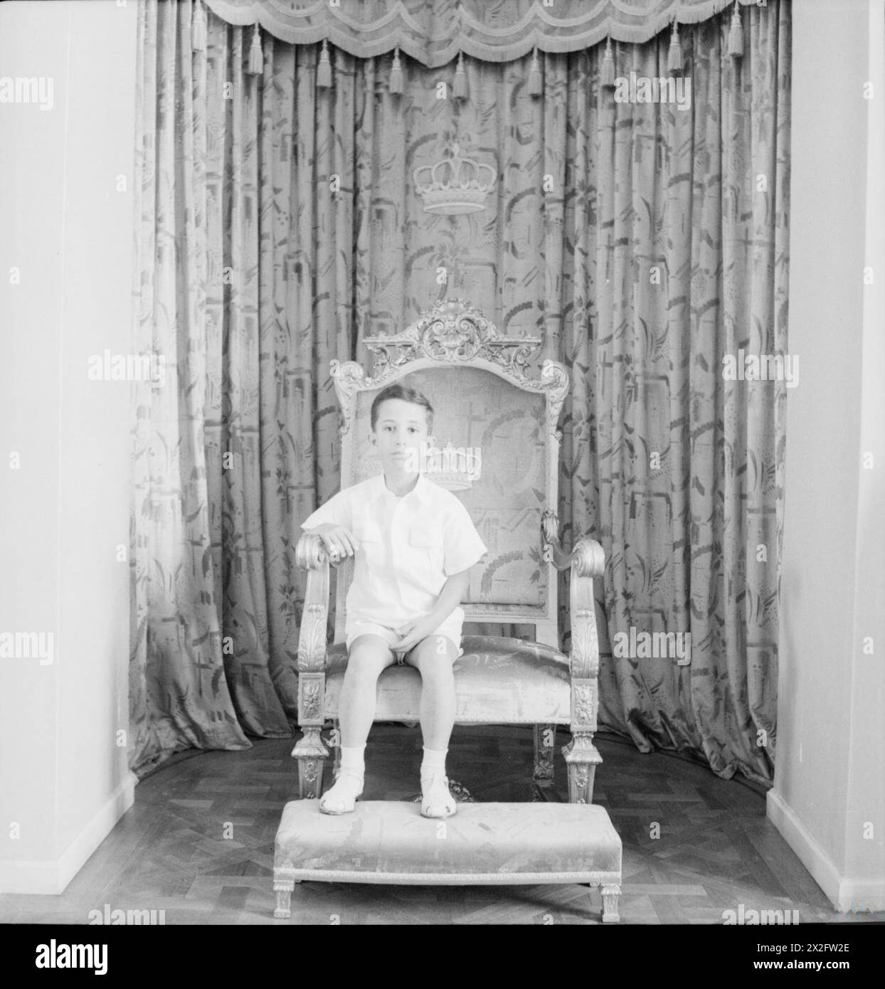 König Faisal II. Von Irak, sieben Jahre alt, sitzt auf seinem Thron im Palais des Fleurs in Bagdad, Irak, 1942 während Beatons Nahost-Besuch. Stockfoto
