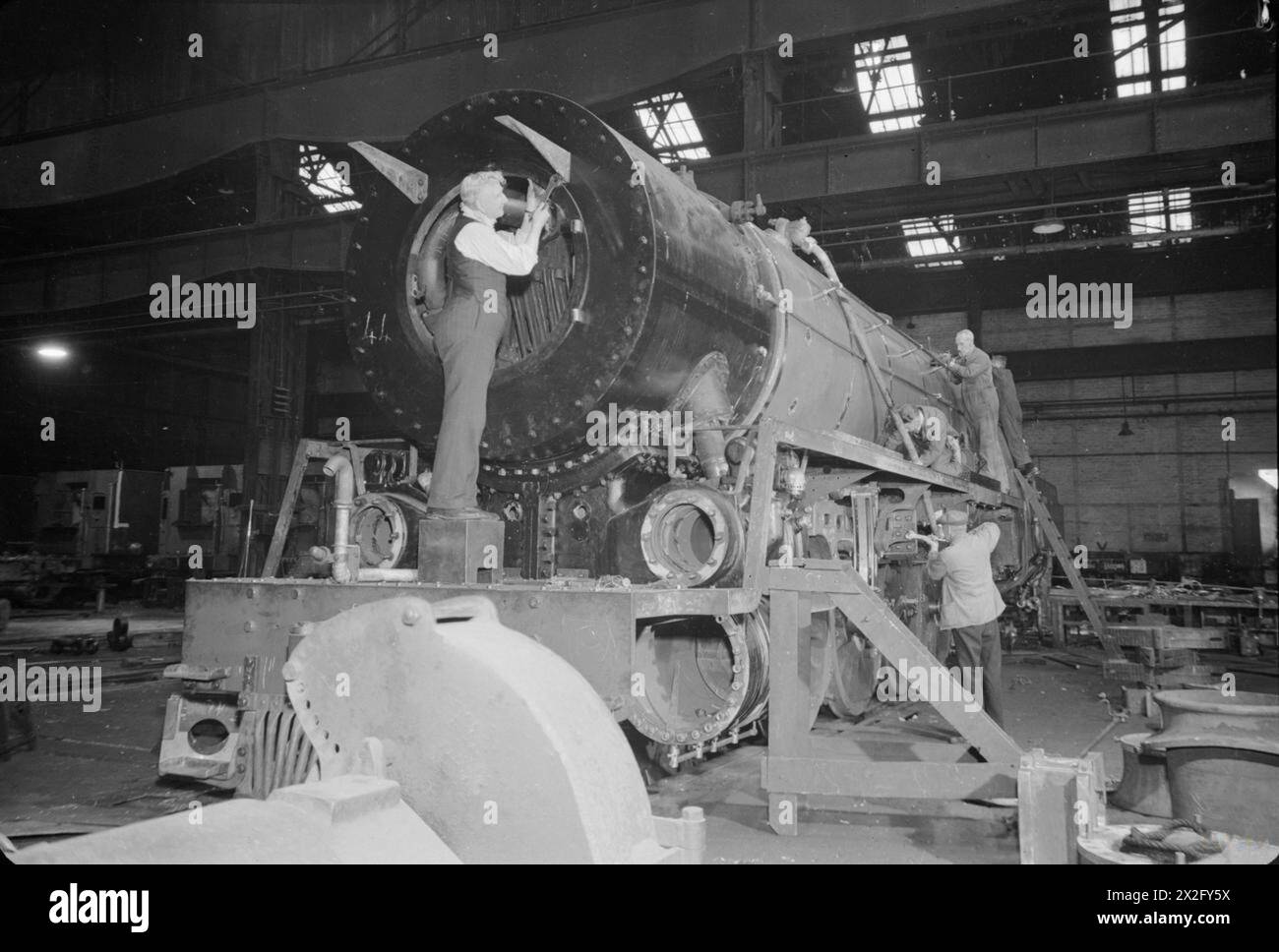 Die Arbeiter veredeln eine Lokomotive der 15F-Klasse der South African Railways, die 1945 in einer Lokomotivfabrik in Großbritannien gebaut wurde. Stockfoto
