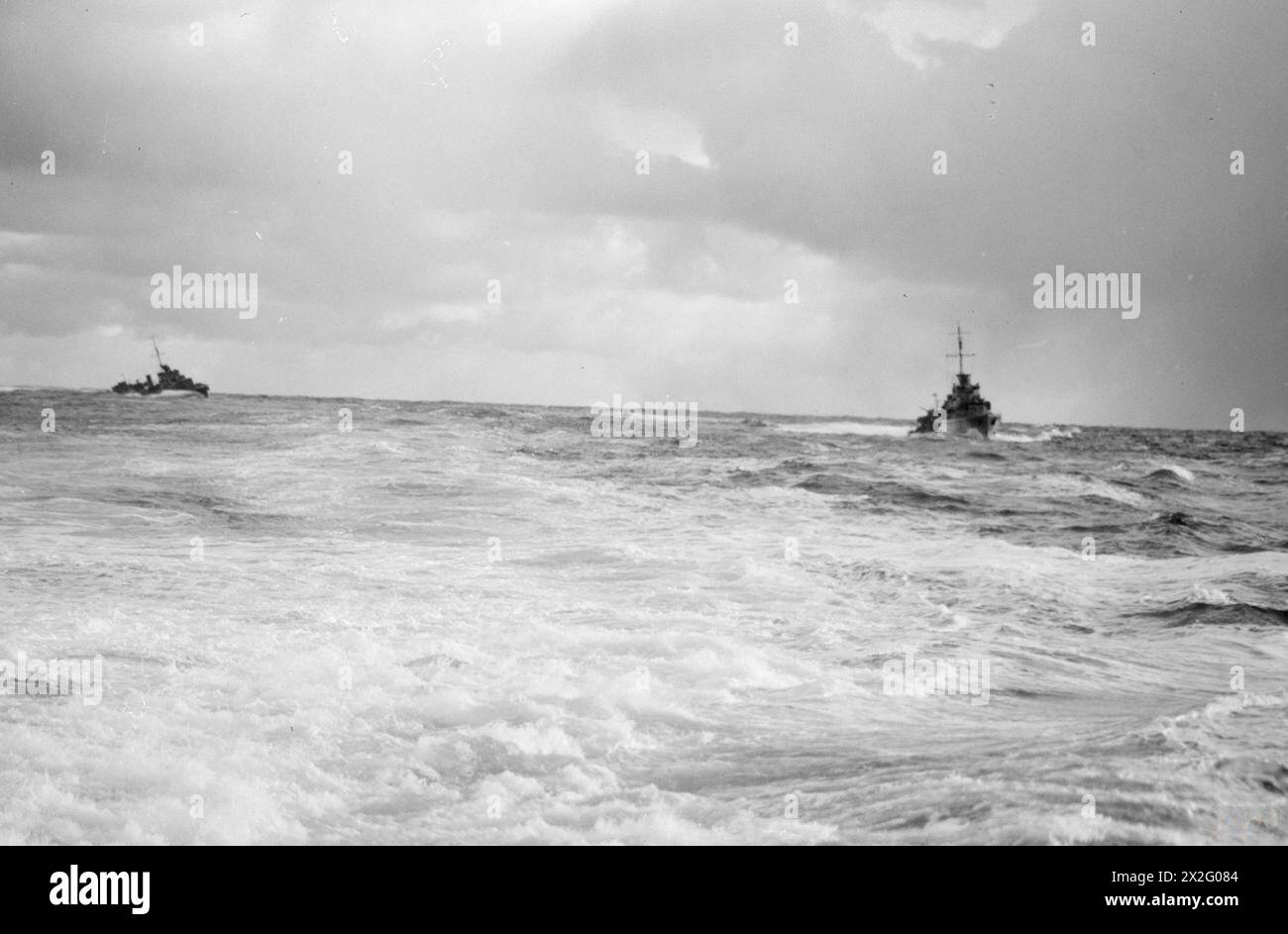 AN BORD DES ZERSTÖRERS HMS WUT AUF SEE. 18. MÄRZ 1942. - Die Zerstörer HMS ECLIPSE (rechts) und HMS OFFA rasen im Gefolge von FURY's Heck bei Sonnenaufgang Stockfoto