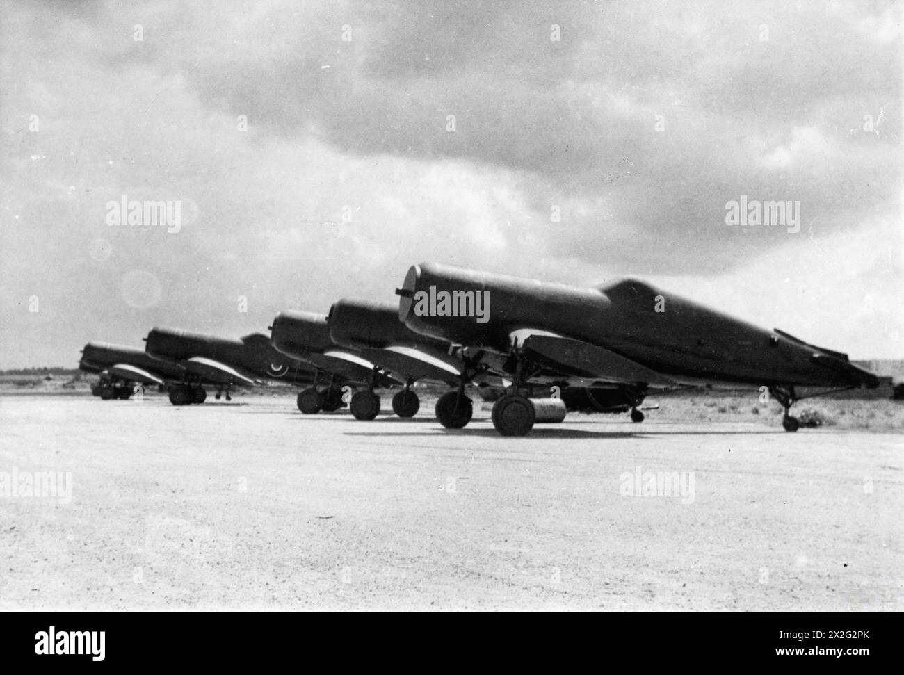 AN EINER ROYAL MARINEFLUGSTATION IN COCHIN. 1945. MAI, WÄHREND DER ENTLADUNG VON FLUGZEUGEN AN DER ROYAL MARINEFLUGSTATION COCHIN, EINER BRITISCHEN MARINEFLUGSTATION AN DER KÜSTE MALABARS. - Wetterfeste, "erenolisierte" Flugzeuge bei Ankunft an der Royal Naval Air Station Cochin. Erenol ist eine gummiartige Lösung, die über den zusammengesetzten Rumpf gesprüht wird und dann trocken eine dünne Haut bildet, die witterungsbeständig ist. Diese Haut wird nach der Ankunft abgezogen und dort, darunter, befindet sich ein brandneuer Rumpf. Hier wartet eine Reihe von 'mumifizierten' erenolisierten Zufall-Vought-Corsair-Kämpfern darauf, entzogen zu werden Stockfoto