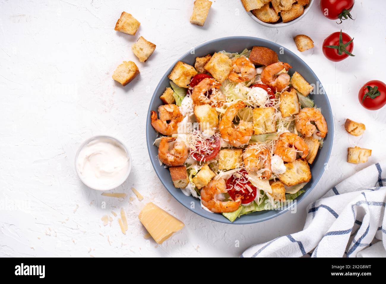Shrimps Caesar Salat in einer Schüssel mit Parmesankäse, Salat, Dressing und Croutons Stockfoto