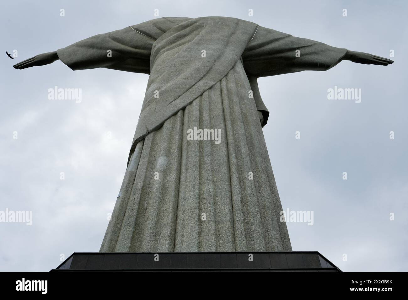 Ungewöhnliche Nahaufnahme der Christusstatue mit einem vorbeifliegenden Vogel. Stockfoto