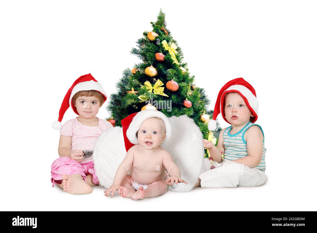 Drei Kinder in weihnachtshüten in der Nähe des Pelzbaums, dicht bedeckt von Weihnachtsschmuck Collage Stockfoto