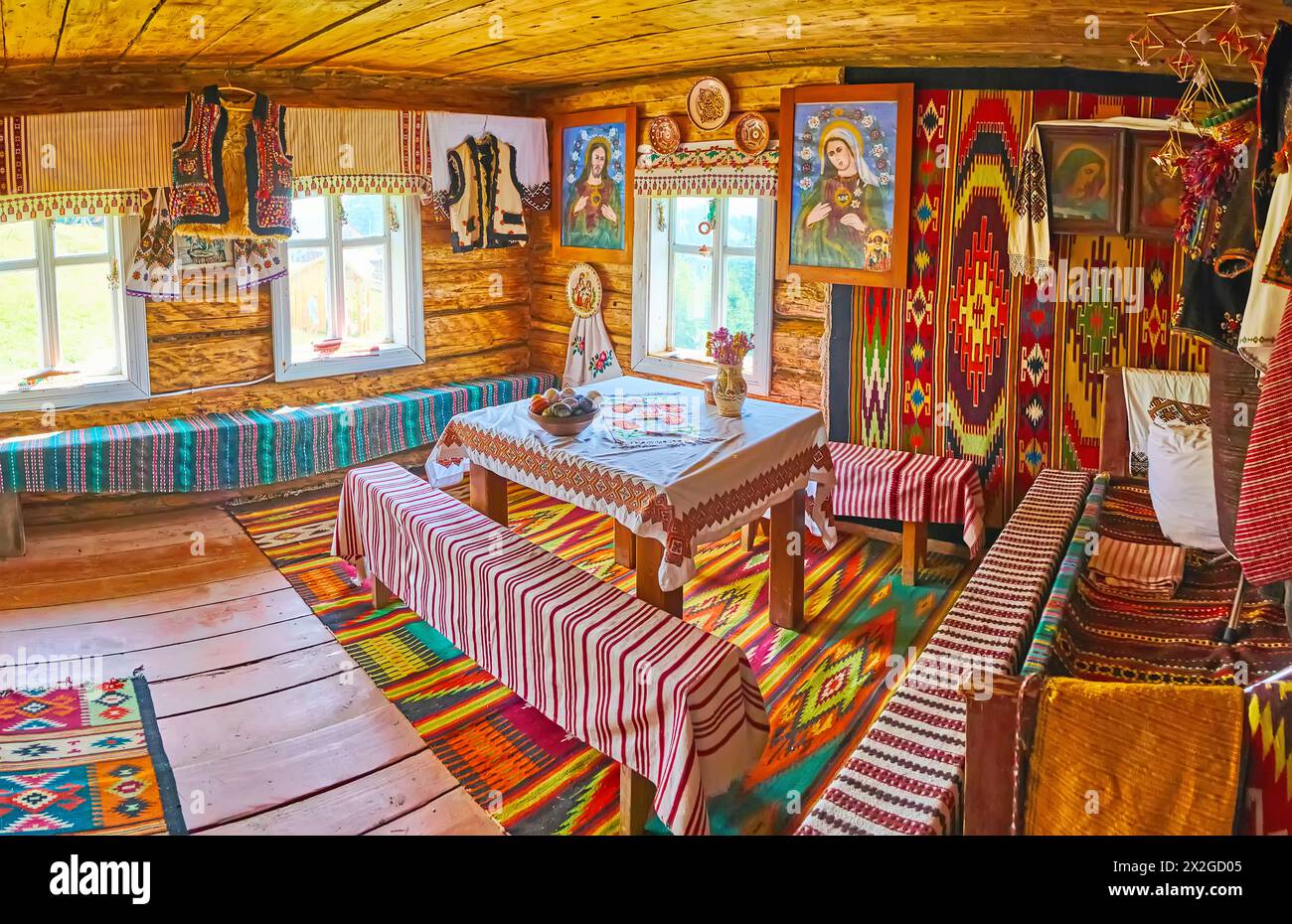 YABLUNYTSYA, UKRAINE - 24. JULI 2021: Panorama des Hutsul-Hauses mit Holzmöbeln, Teppichen, Ikonen und Rushnyk-Handtüchern, Bergtal-Paprika (Pol Stockfoto