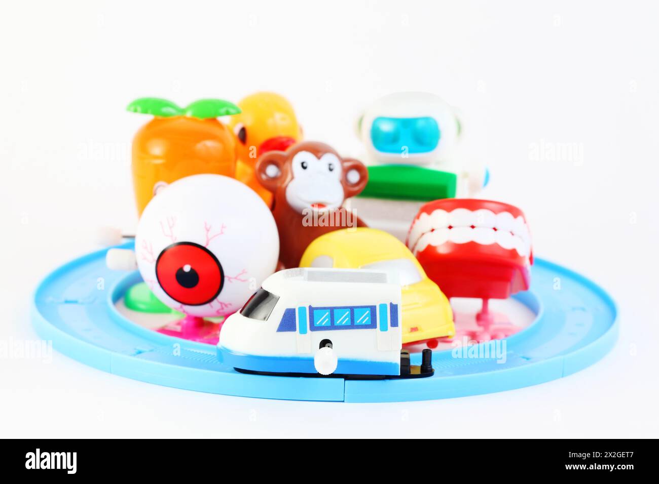Gruppe von acht kleinen, hellen Uhrwerk-Spielzeugen auf weißem Hintergrund Stockfoto