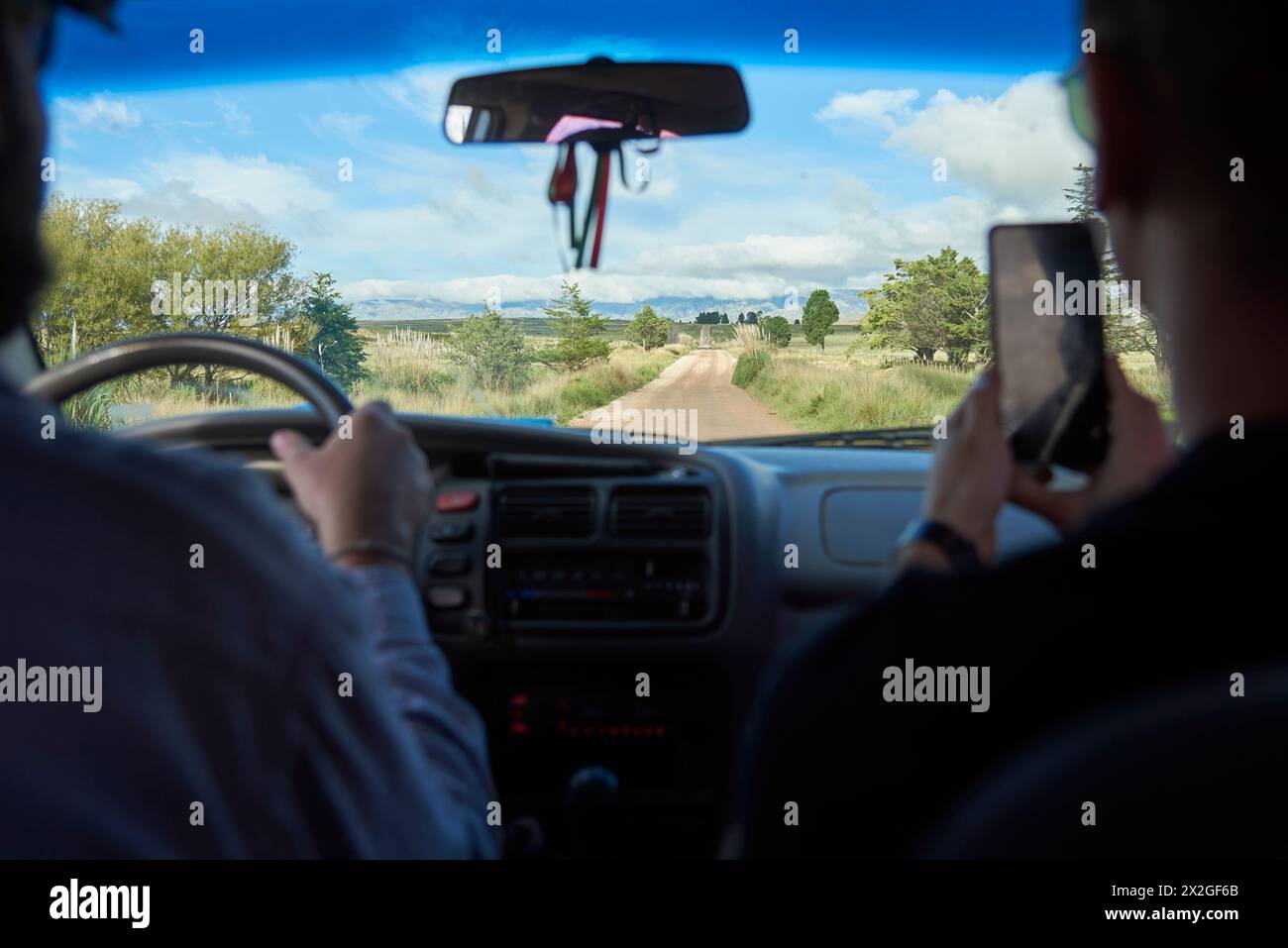 Blick aus dem hinteren Teil eines Autos, zwei Freunde reisen in Los Gigantes, ein touristisches Reiseziel in den Bergen zum Wandern, Trekking, in Cordoba, Argentin Stockfoto