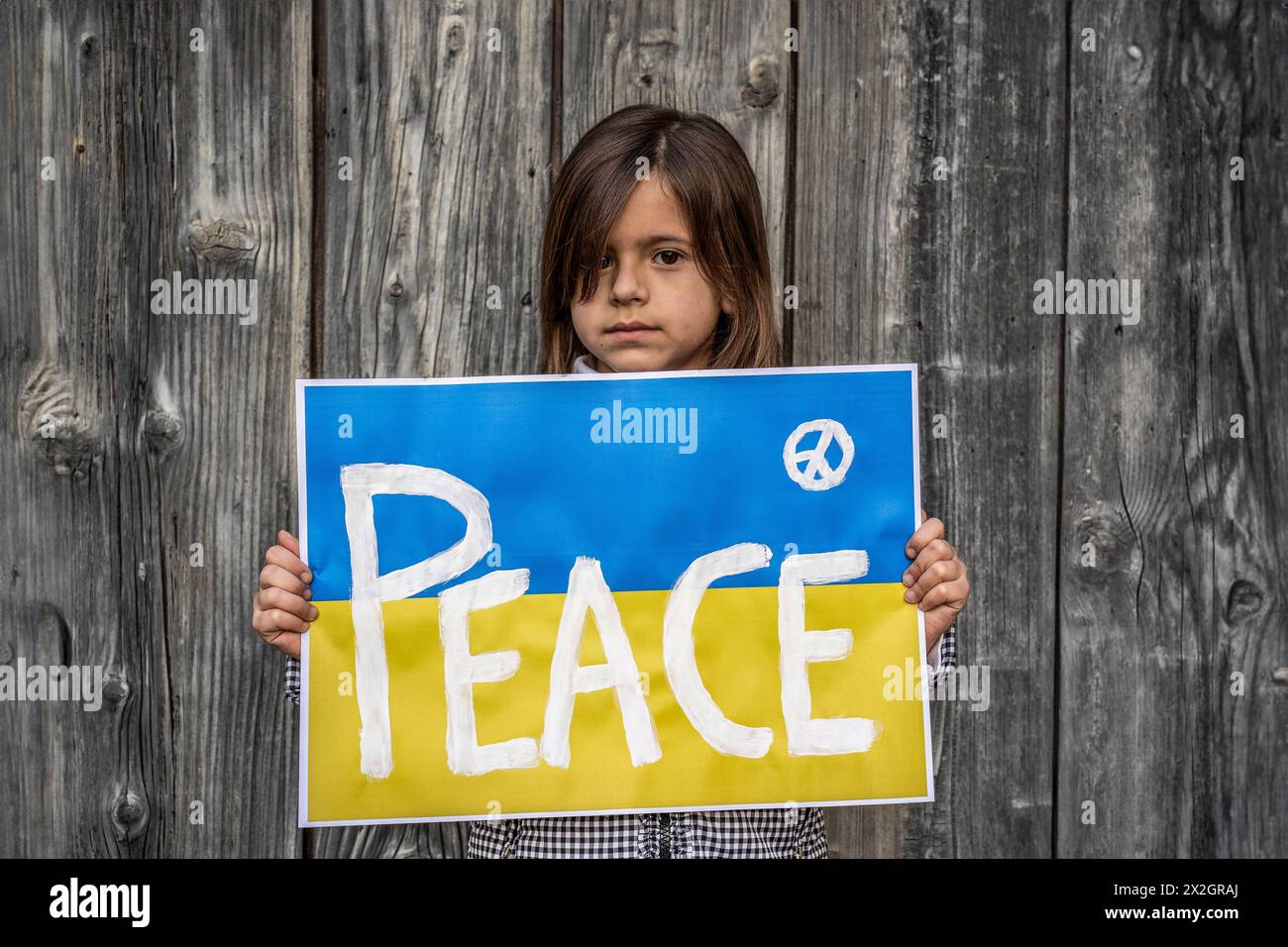 Feierliches Plädoyer des Kindes für Frieden im Konflikt. Ein aufrichtiger Aufruf zu weltweiter Waffenruhe und Einheit. Stockfoto