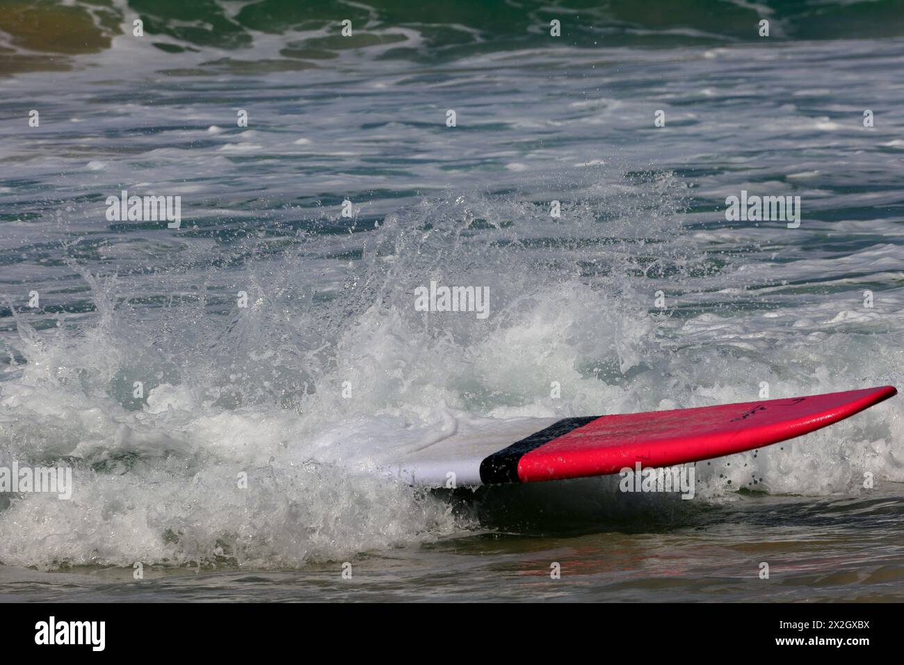 Einsames Surfbrett kommt alleine ohne Surfer am Ufer des Surfstrands El Cotillo, Fuerteventura an. Vom Februar 2024 Stockfoto