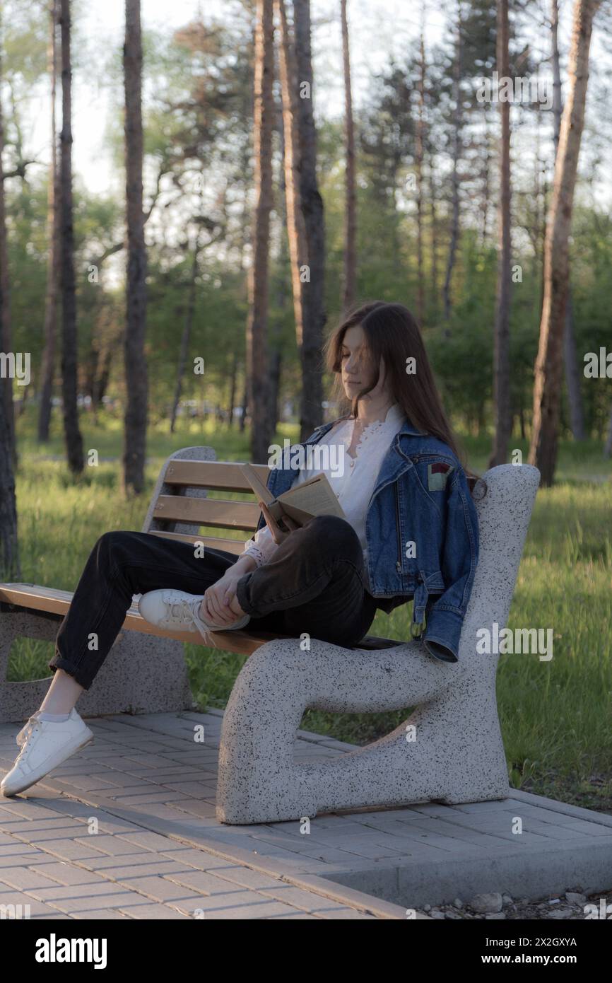 Porträt eines schönen Mädchens mit einem Buch. Es passiert irgendwo im Park. Nahaufnahme. Stockfoto Porträt eines schönen Mädchens mit einem Buch. Es passiert irgendwo im Park. Nahaufnahme. Stockfoto