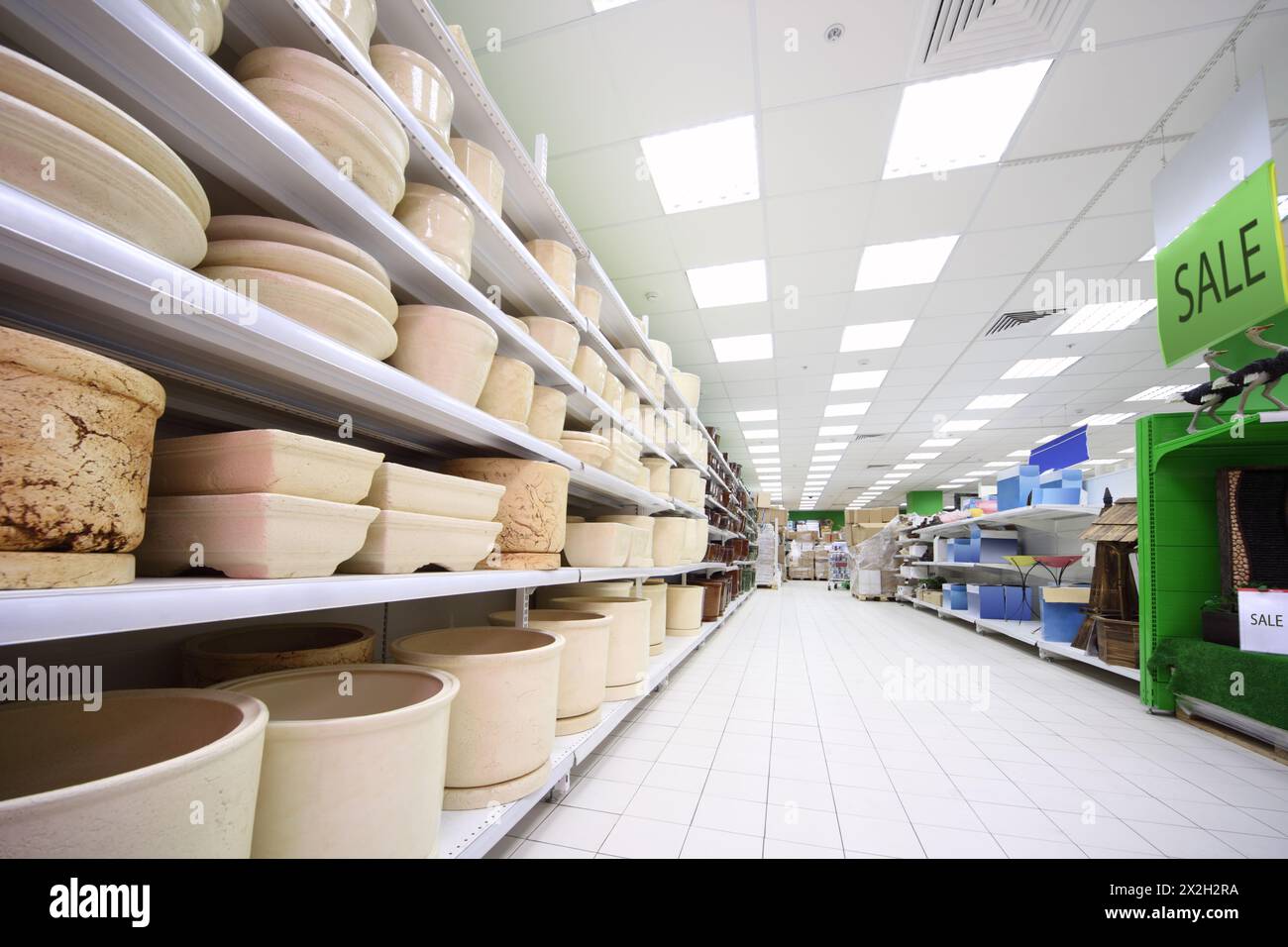 Regale mit verschiedenen beigefarbenen Töpfen aus Ton in einem großen Supermarkt Stockfoto