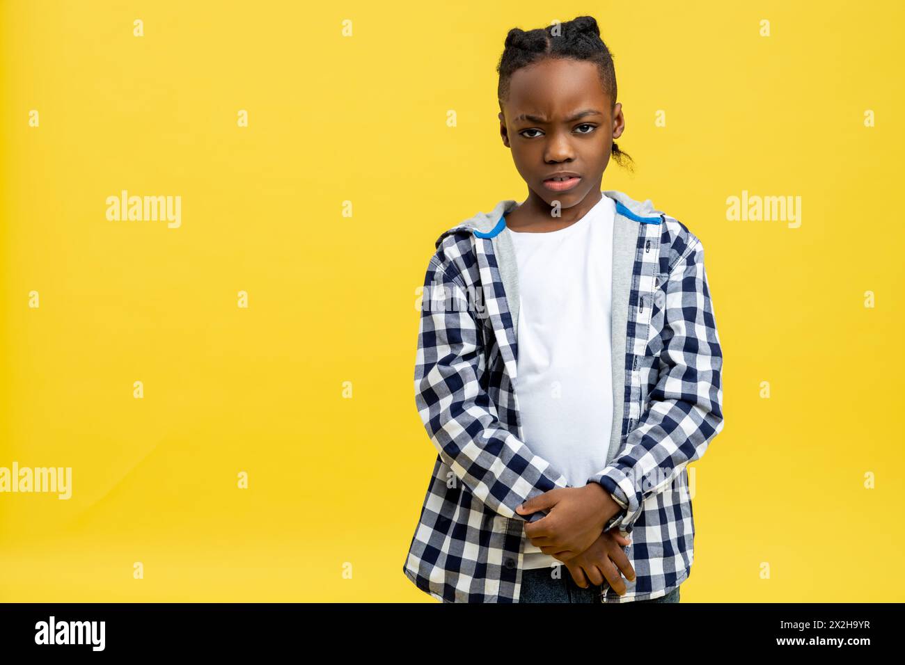 Junge in kariertem Hemd, der launisch und runzelig aussieht Stockfoto