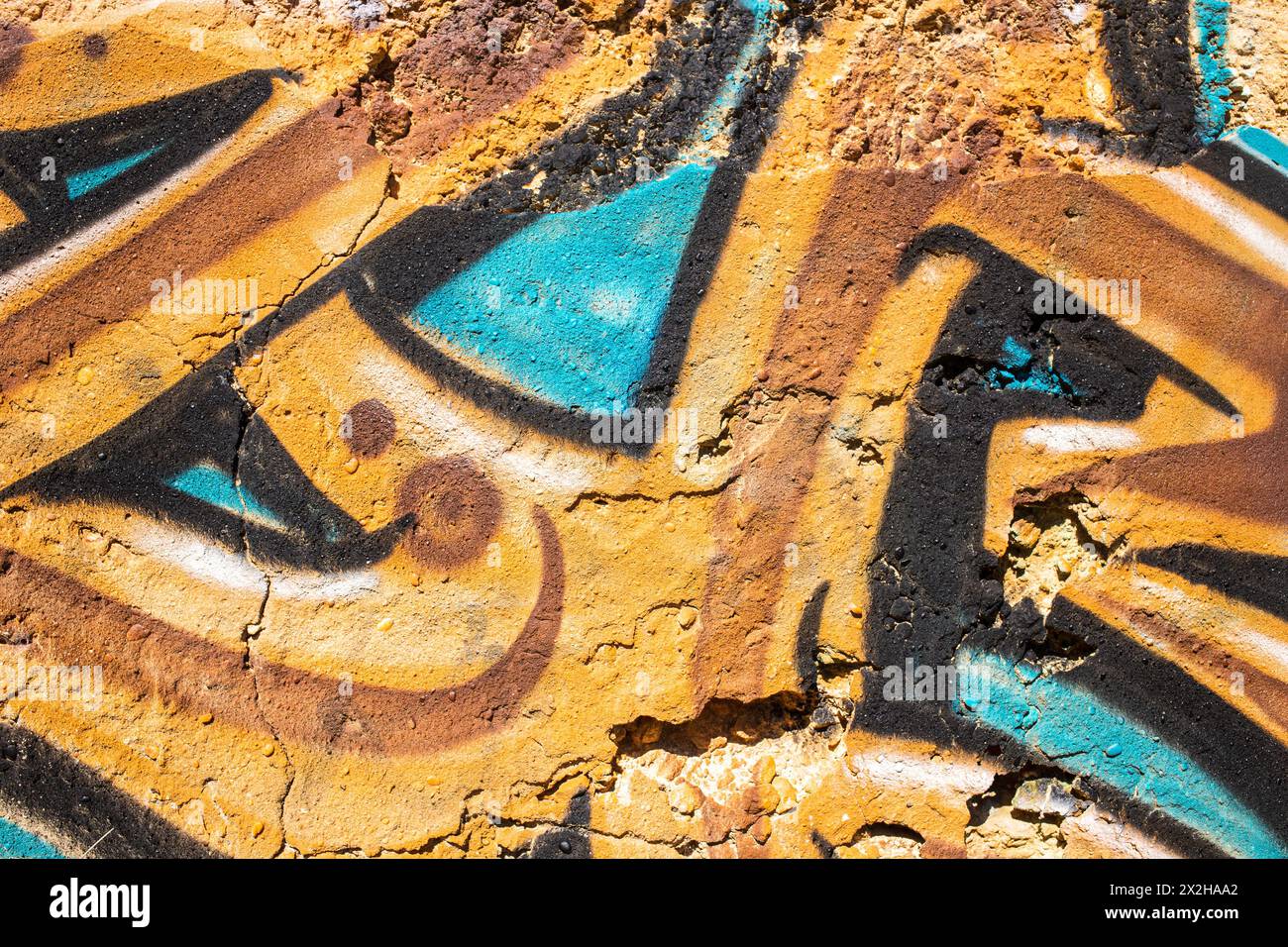 Graffiti in ockerfarbenen und türkisfarbenen Farben an der Wand einer Ruine gemalt, fotogapht in Portugal Stockfoto