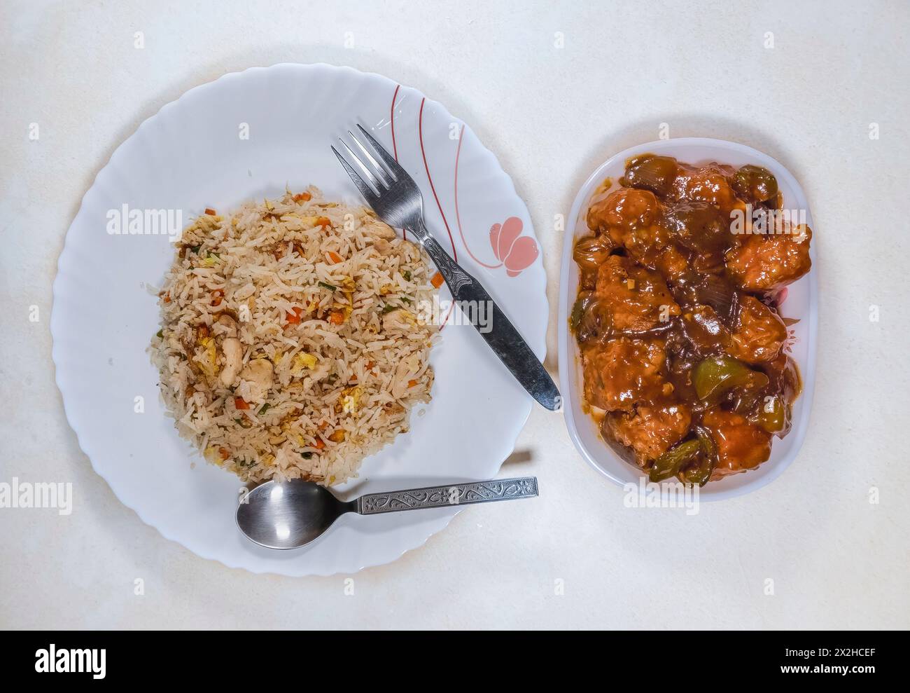 Leckere chinesische Küche mit gebratenem Huhn-Reis mit knochenlosem Chili-Huhn auf weißem Hintergrund. Stockfoto