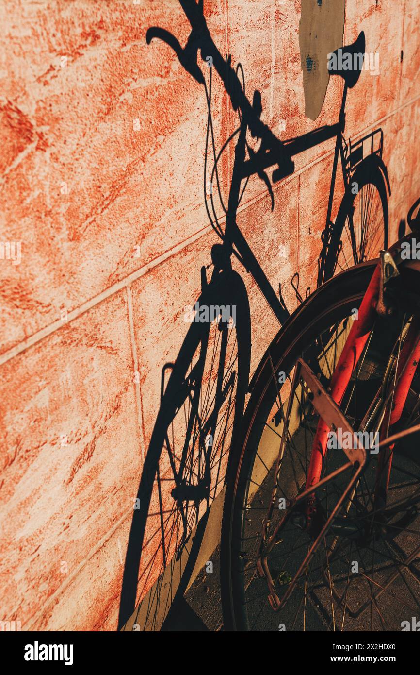 Schatten eines Fahrrads an der Gebäudewand an der Straße, selektiver Fokus Stockfoto