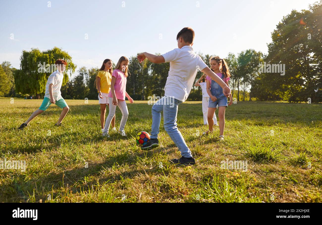 Fröhliche Kinder Jungen und Mädchen Rennen in den Sommerferien auf Ball zu spielen zusammen. Stockfoto